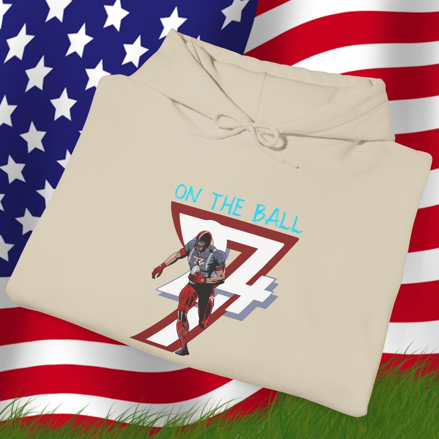 Beige american football hoodie with hand-drawn player and "On The Ball" text, displayed on American flag background