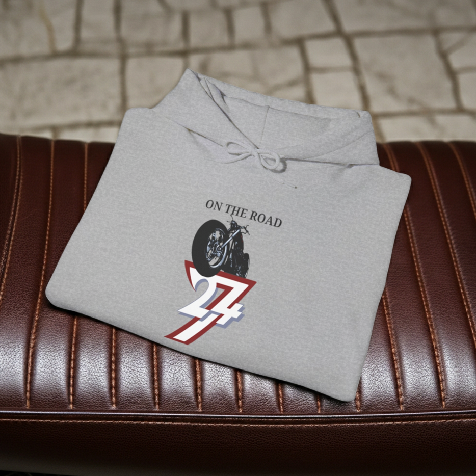 Folded gray vintage bike hoodie with "On The Road" and 24/7 design print on brown leather surface