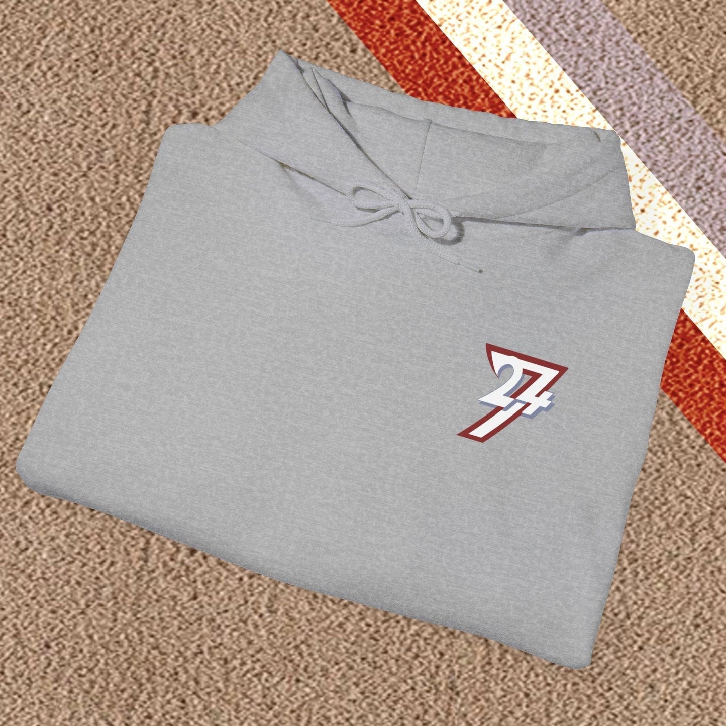 Folded grey stylish hoodie with twentyfourseven logo on carpet background