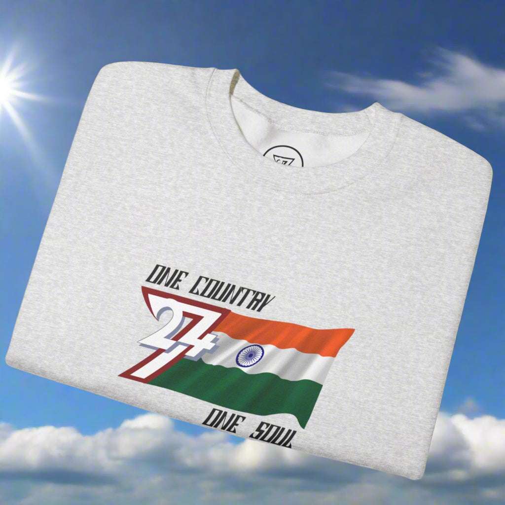 Folded light gray sweatshirt with India flag design and "One country one soul" slogan on chest against blue sky background