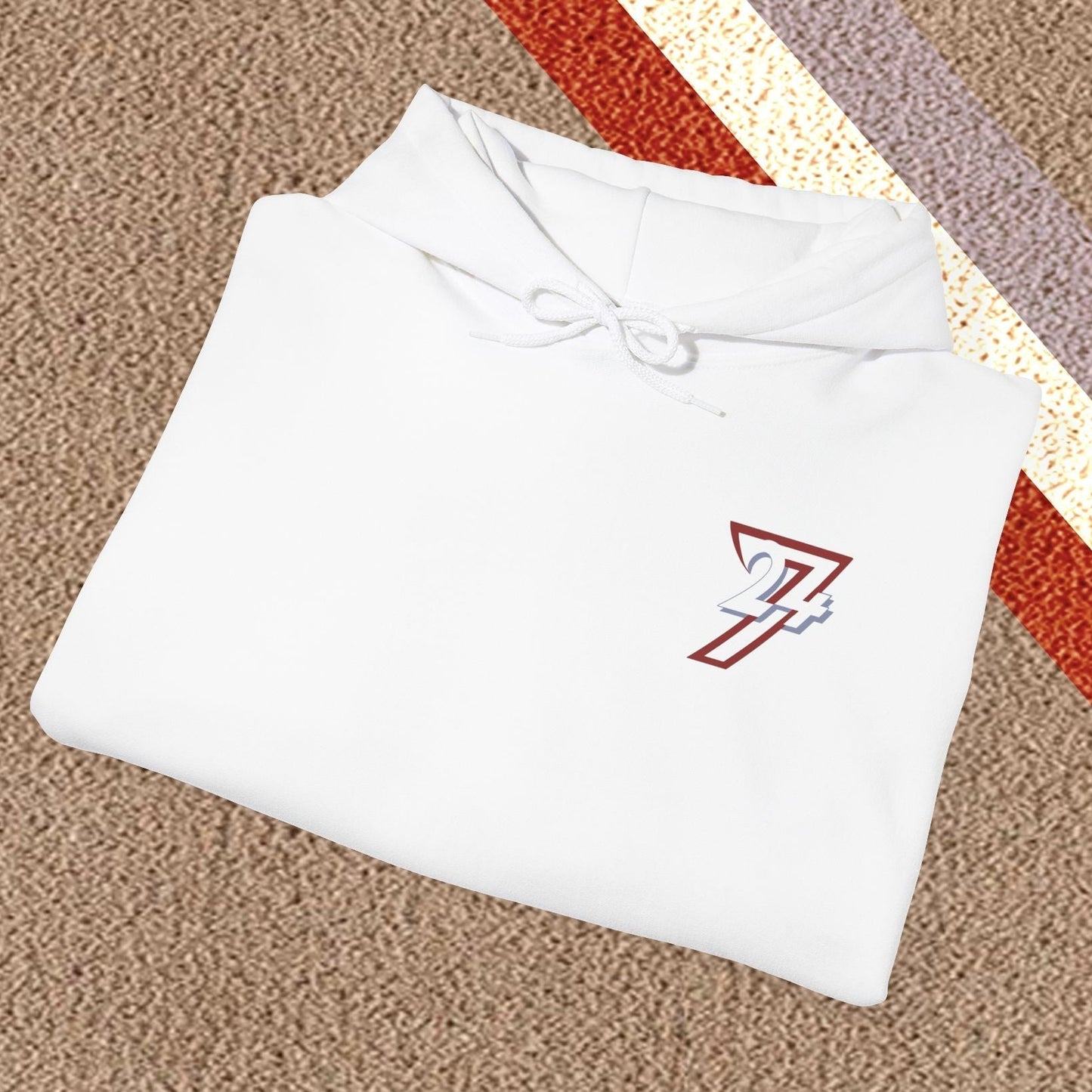 Folded white stylish hoodie with twentyfourseven logo on beige carpet