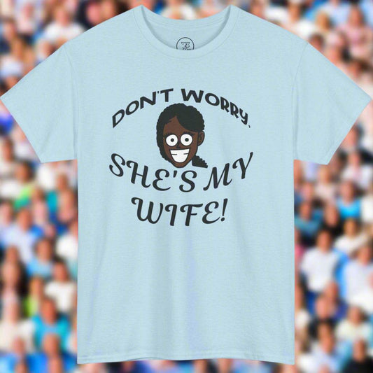 Light blue unisex Kiss Cam funny T-shirt with "Don't Worry, She's My Wife!" text and cartoon face design.