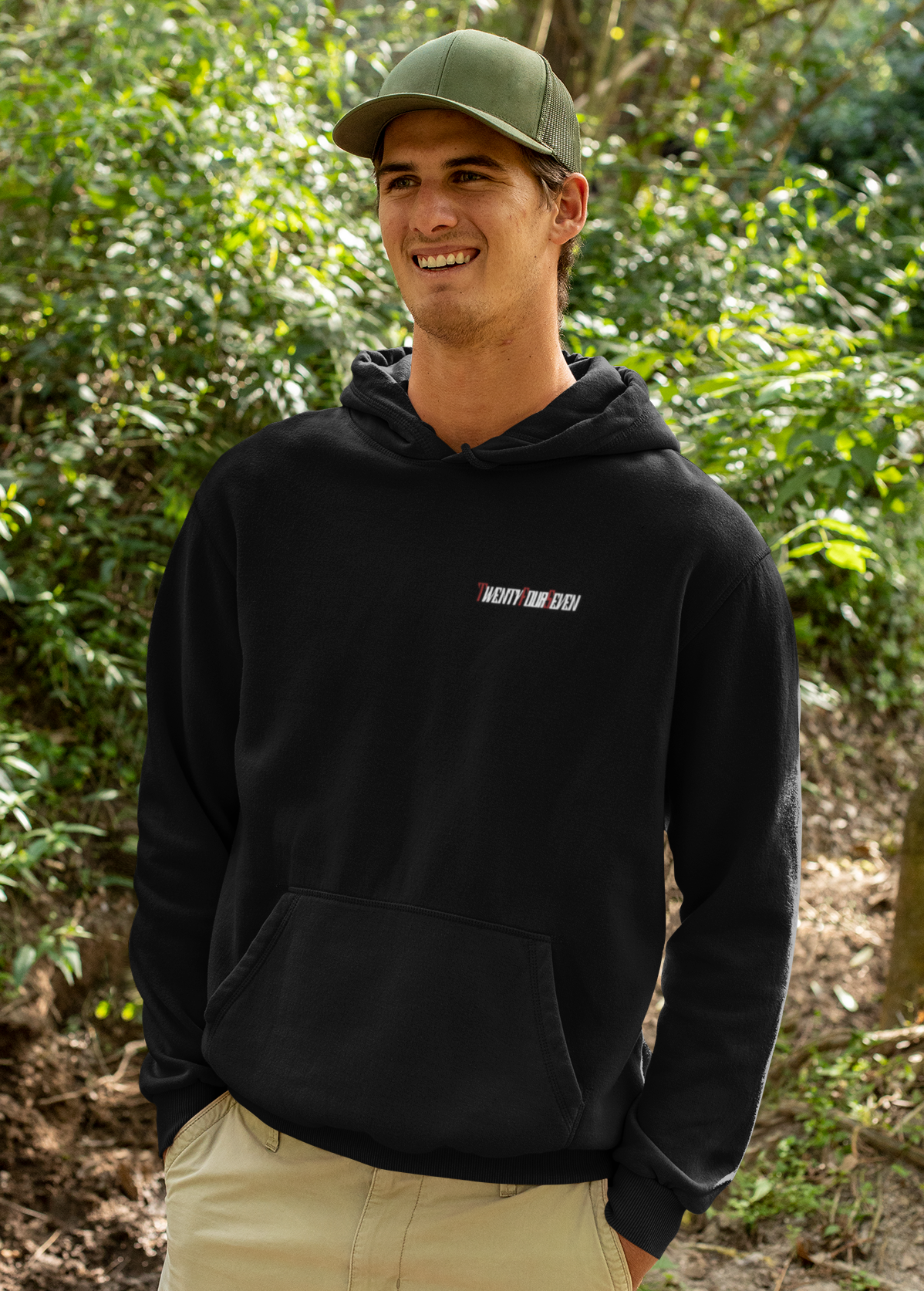 Man wearing black unique printed hoodie with Twentyfourseven logo and kangaroo pocket outdoors