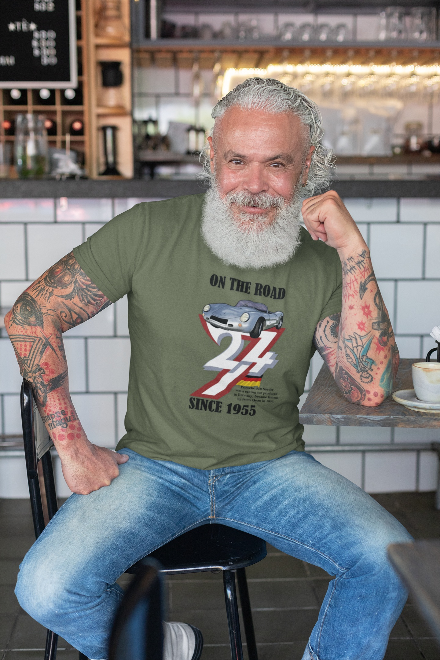 Man wearing vintage Porsche tee with 1955 car design sitting in cafe