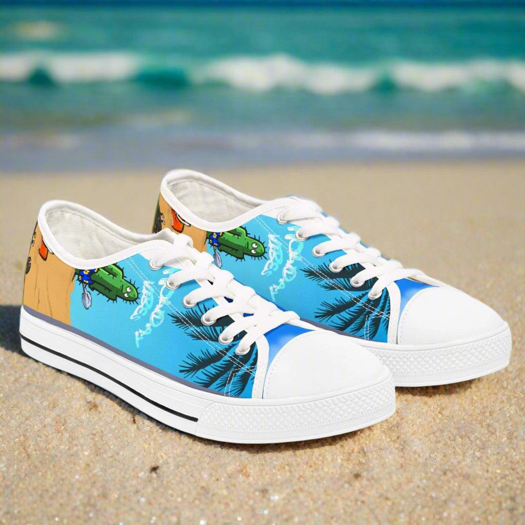 Women's low top Tropic Feel sneakers with tropical beach design and white rounded pleather toe on sand background