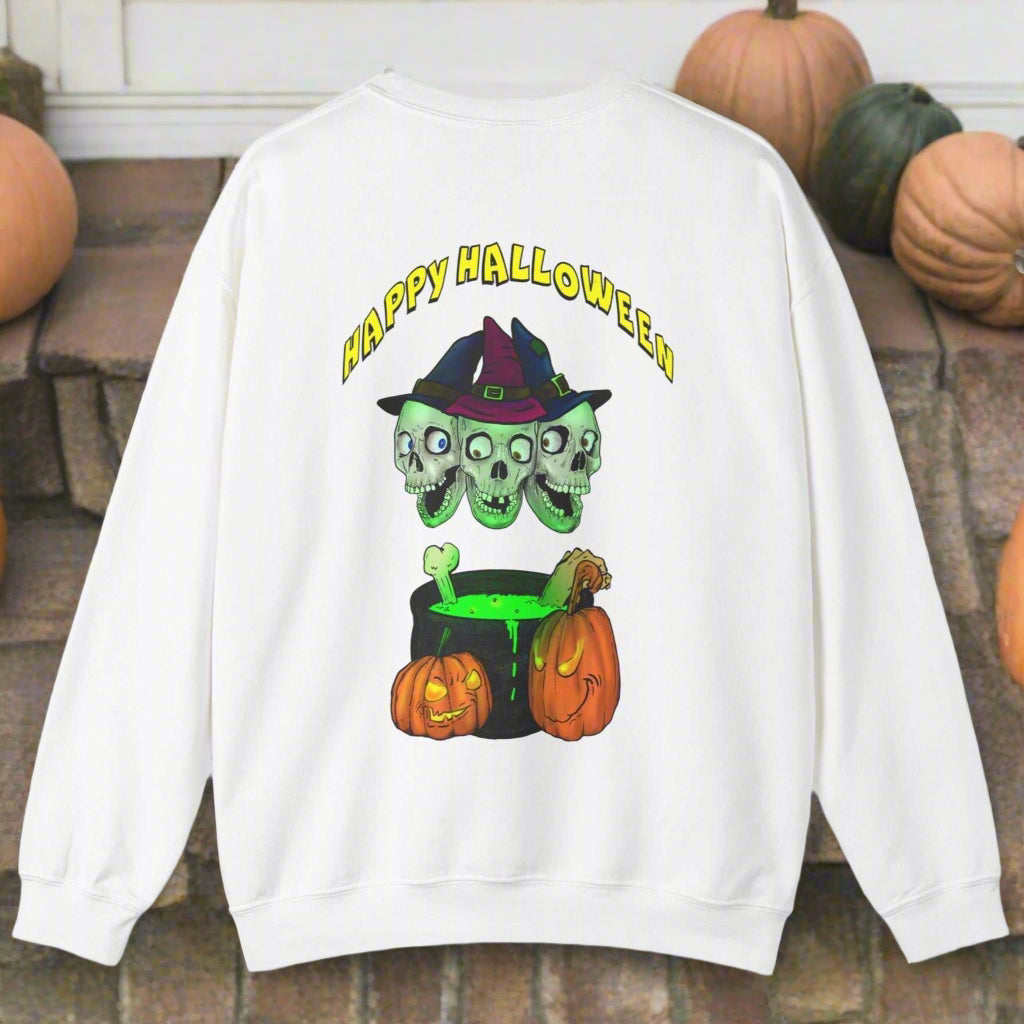 White Halloween sweatshirt with three skulls wearing witch hats, a bubbling green cauldron, and pumpkins, featuring "Happy Halloween" text on back