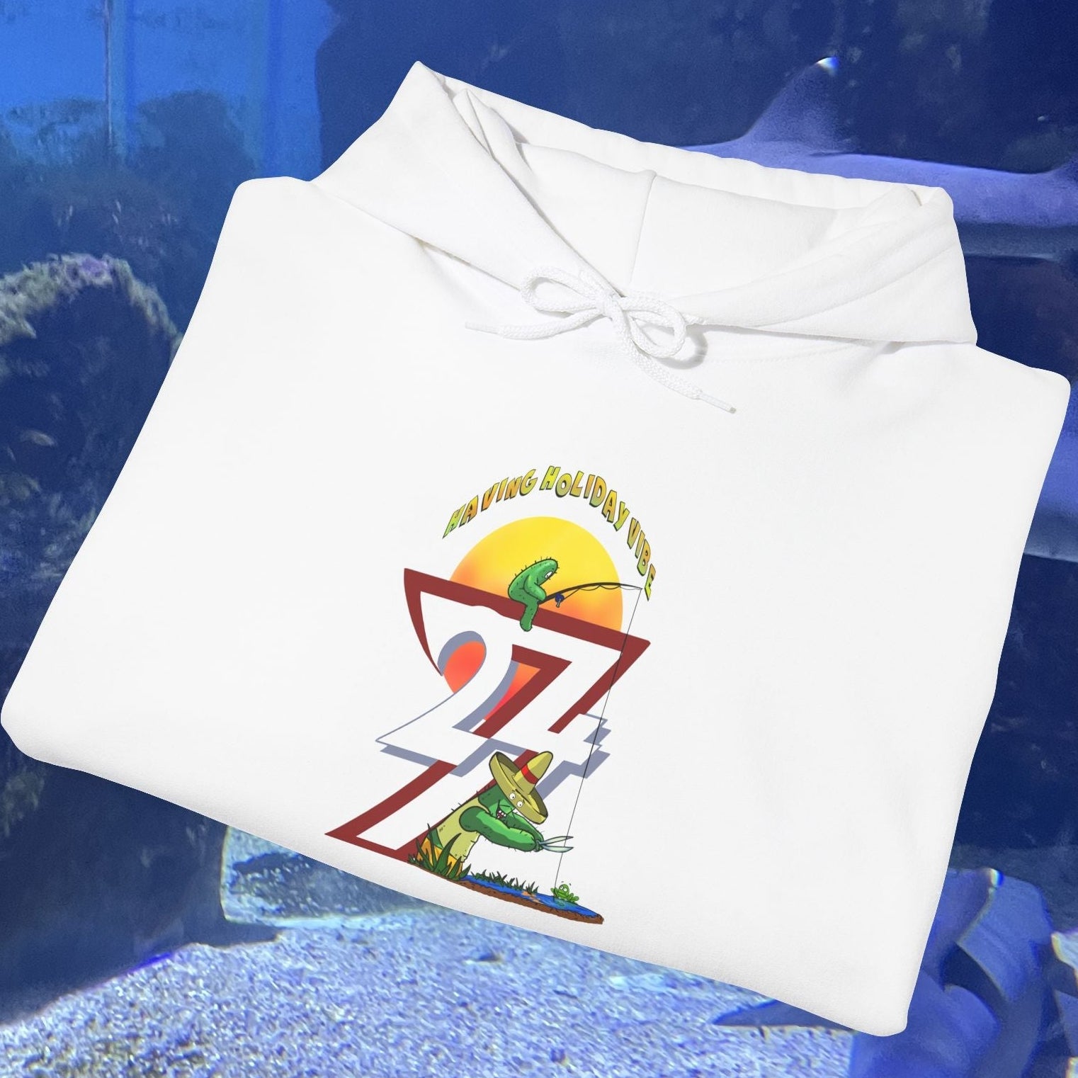 White Funny Fishing Hoodie with cactus and sunset design folded on aquarium background