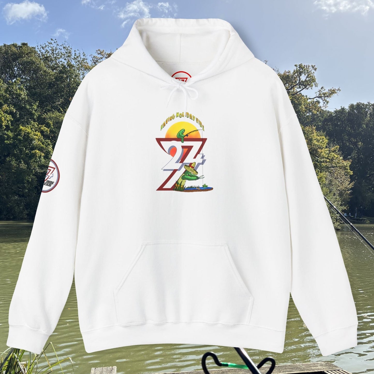 White Funny Fishing Hoodie with colorful fishing and cactus graphic on front, long sleeves, and front pocket, displayed outdoors by lake.