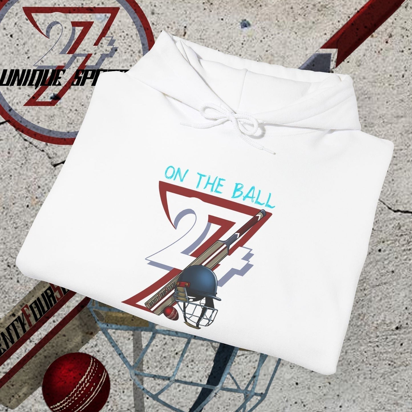 White cricket hoodie sweatshirt with unique "On The Ball 24/7" illustration, cricket bat, ball, and helmet graphics on concrete background