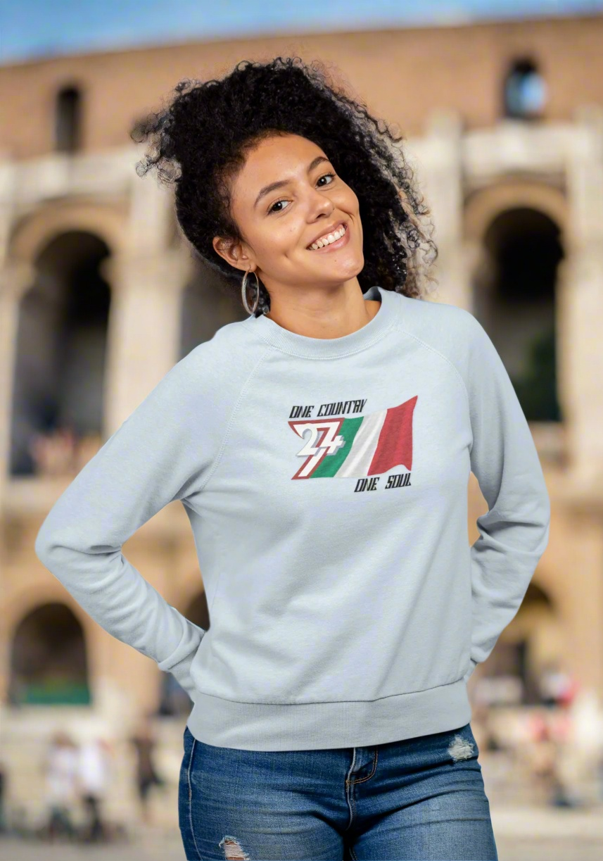 Woman wearing light gray Italian flag sweatshirt with hand-drawn design outdoors by historical building