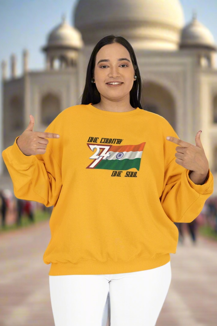 Woman wearing yellow sweatshirt with India flag design and "One country one soul" slogan in front of Taj Mahal