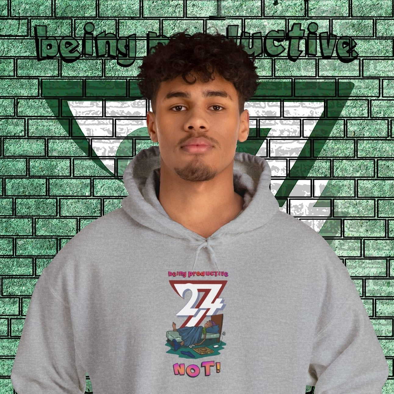 funny custom hoodie with cartoon lazy teen design in grey on male model against green brick wall background