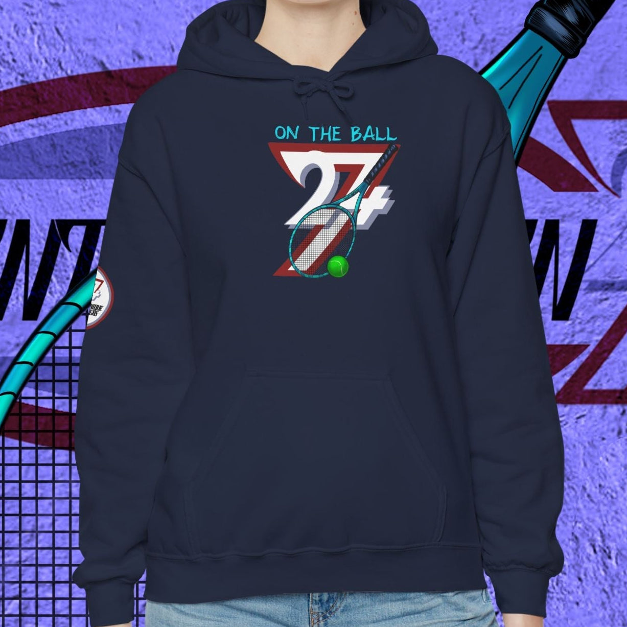 woman wearing navy tennis hoodie with hand-drawn tennis gear design and "On The Ball" text