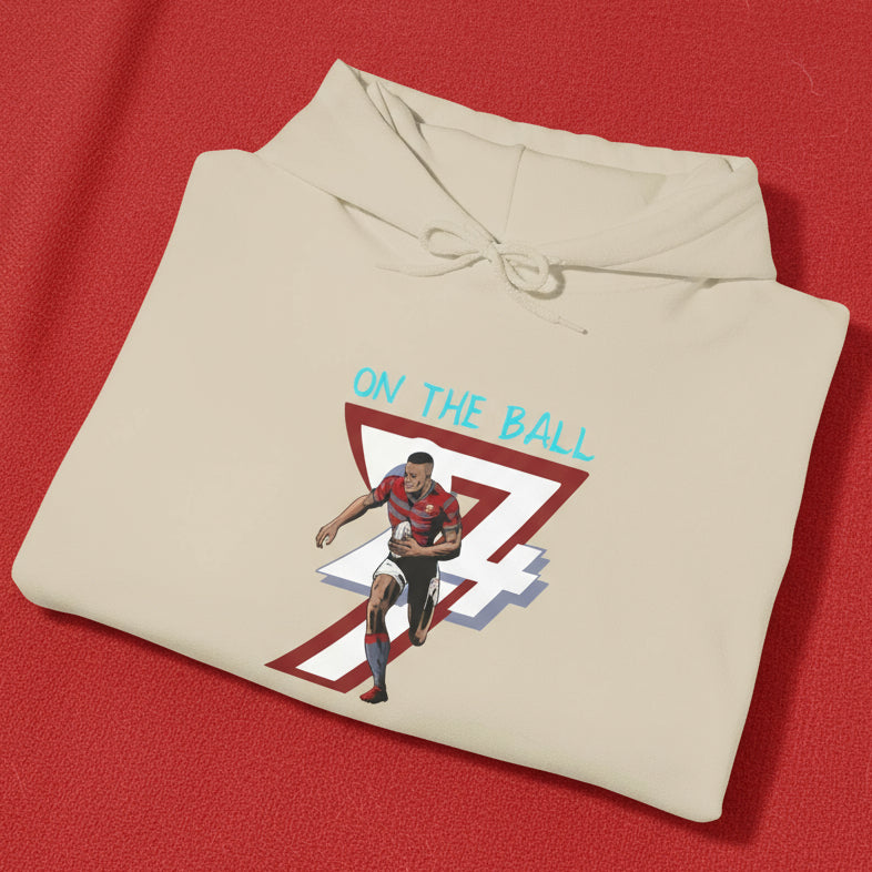 Beige rugby hoodie with vibrant hand-drawn rugby player and number 7 design, folded view.