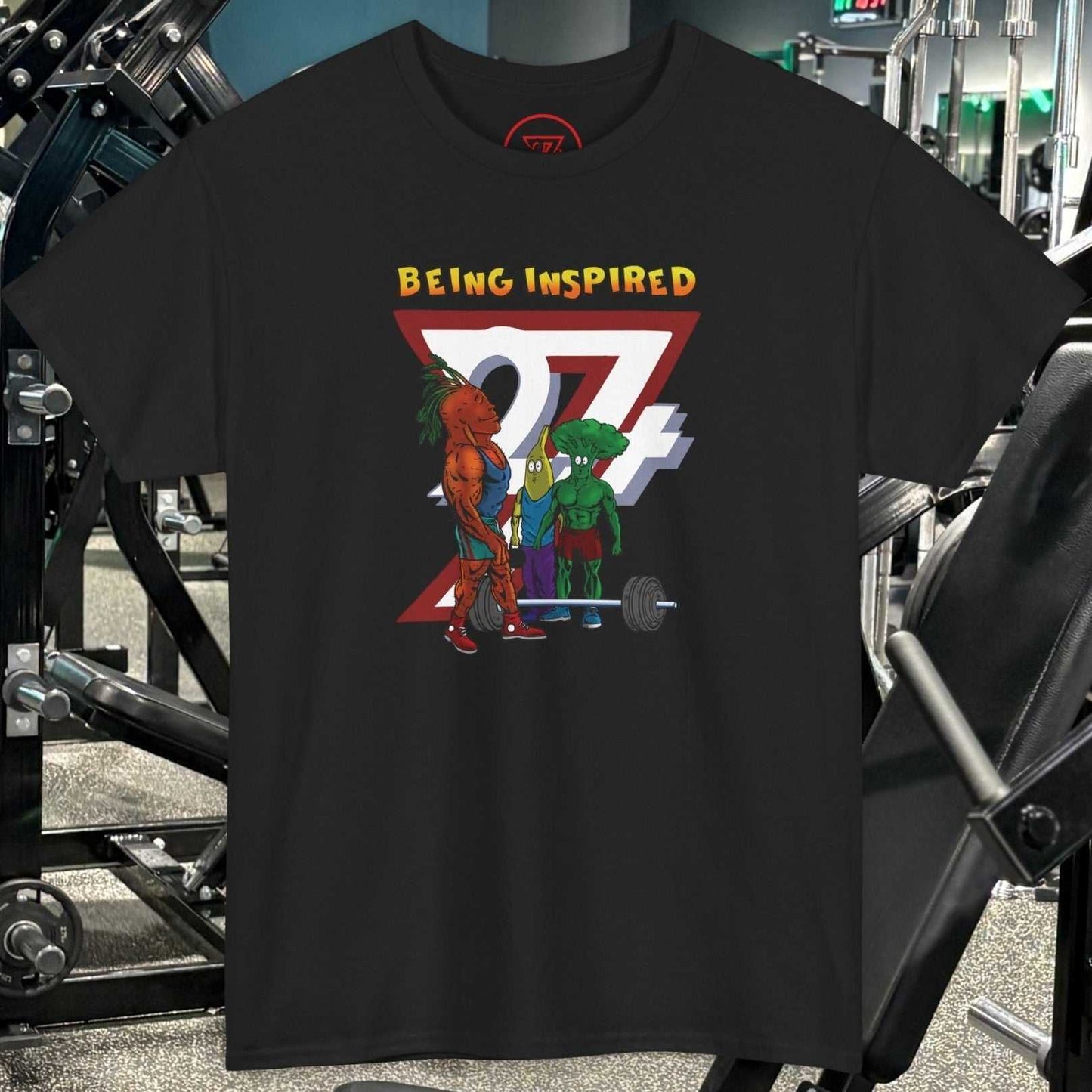 Black Funny Carrot Gym Tee with cartoon vegetables lifting weights and "Being Inspired" text in gym setting