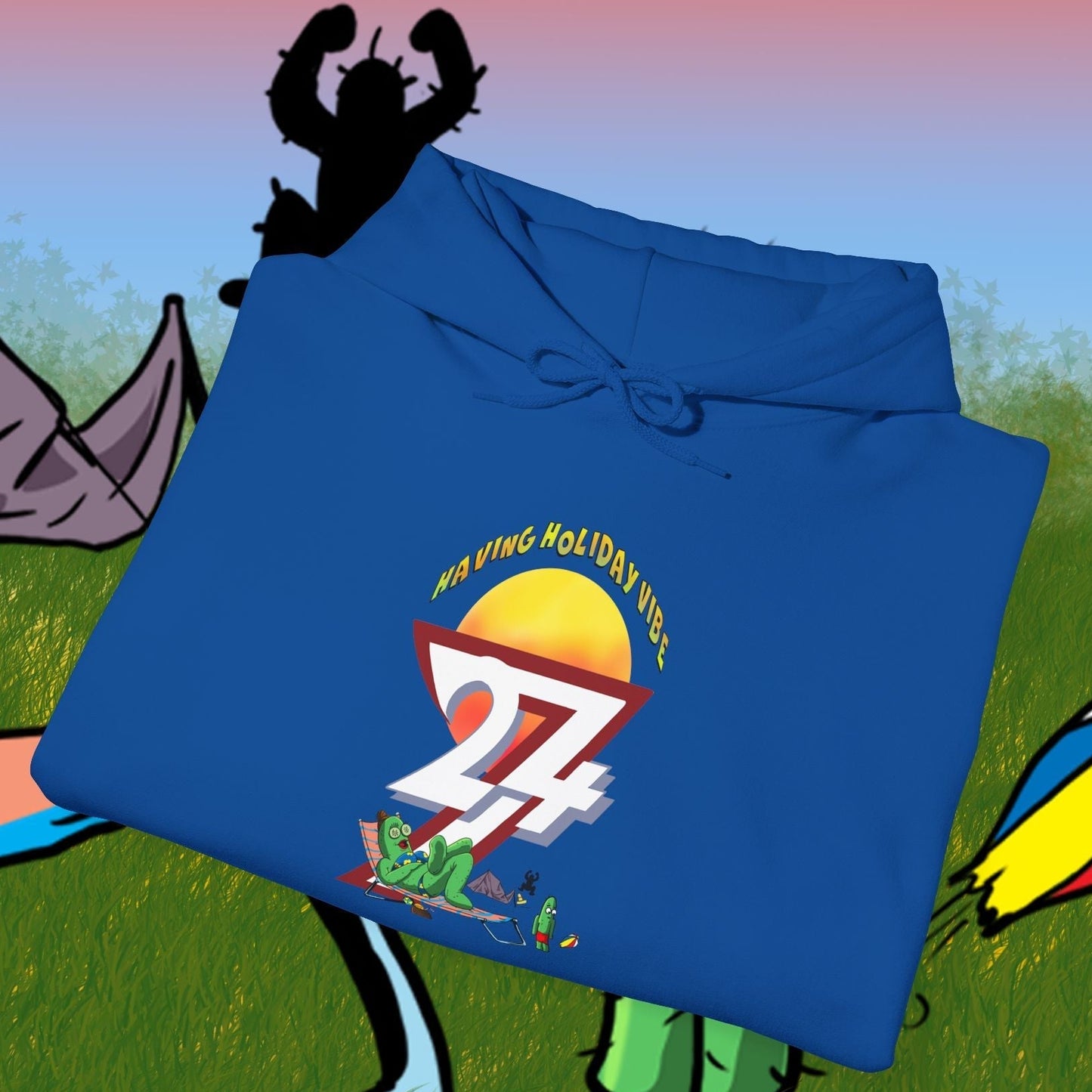 Blue cactus hoodie with cartoon character and camping design folded on illustrated outdoor background