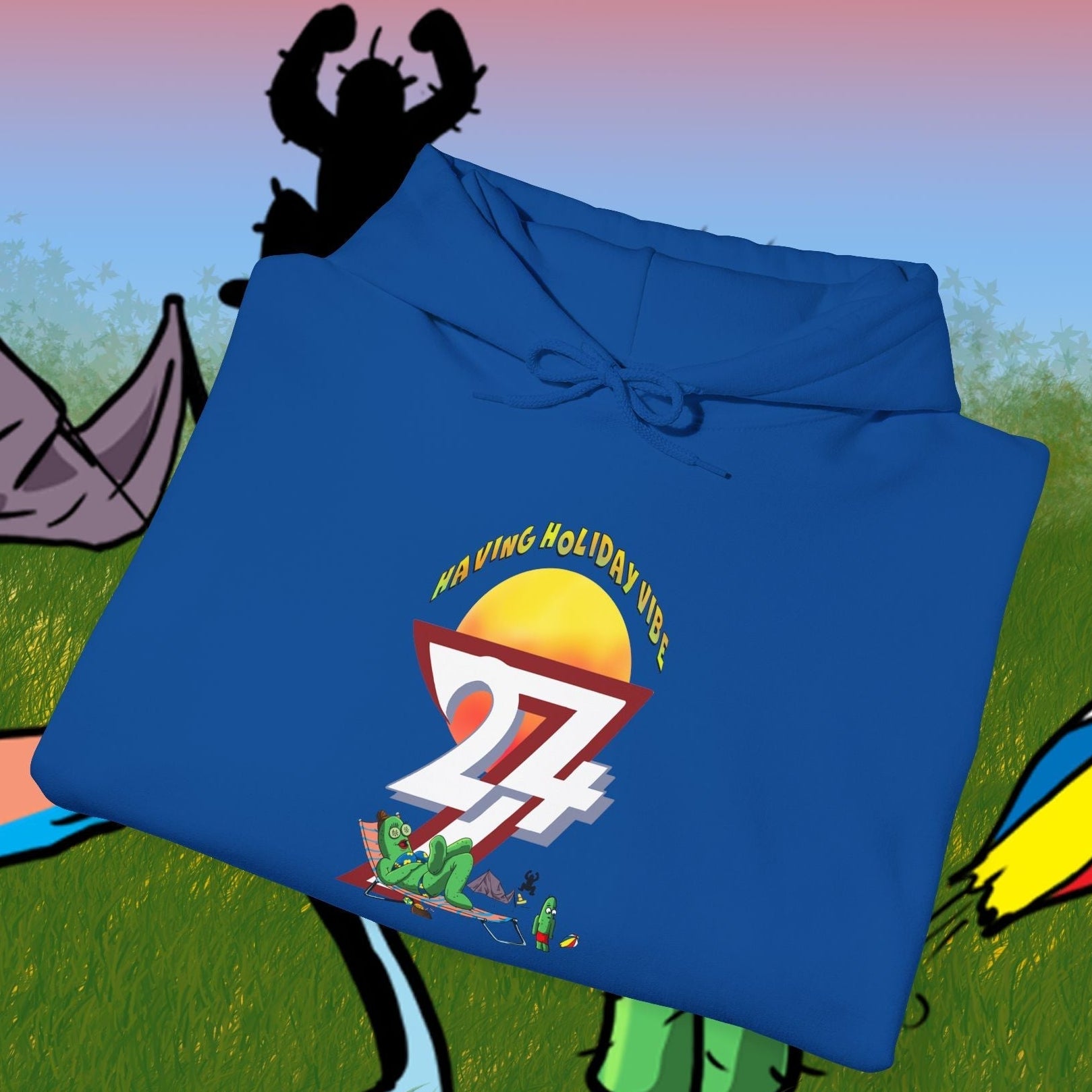 Blue cactus hoodie with cartoon character and camping design folded on illustrated outdoor background