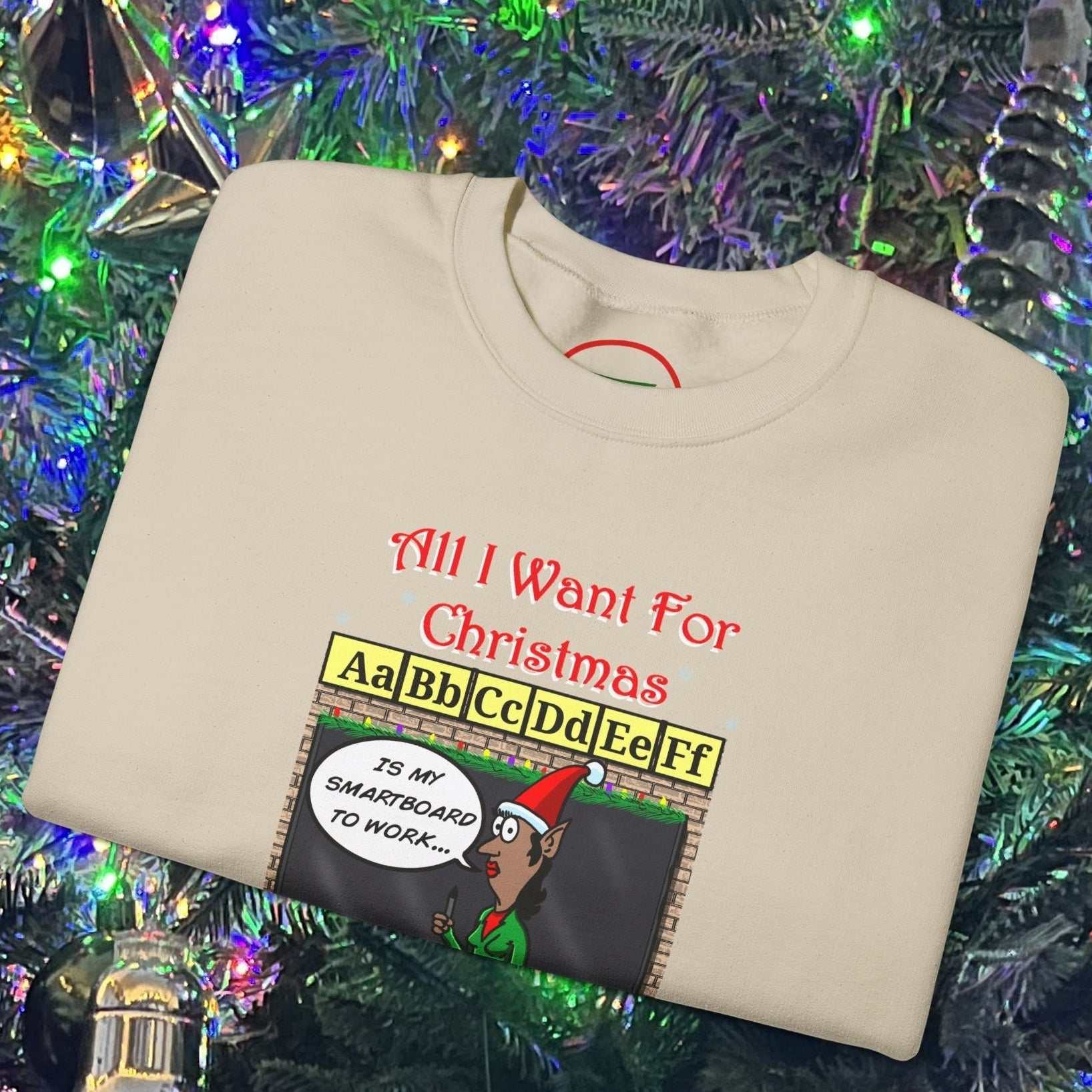 Christmas Teacher Comic Sweatshirt with funny cartoon teacher and holiday design folded on Christmas tree background