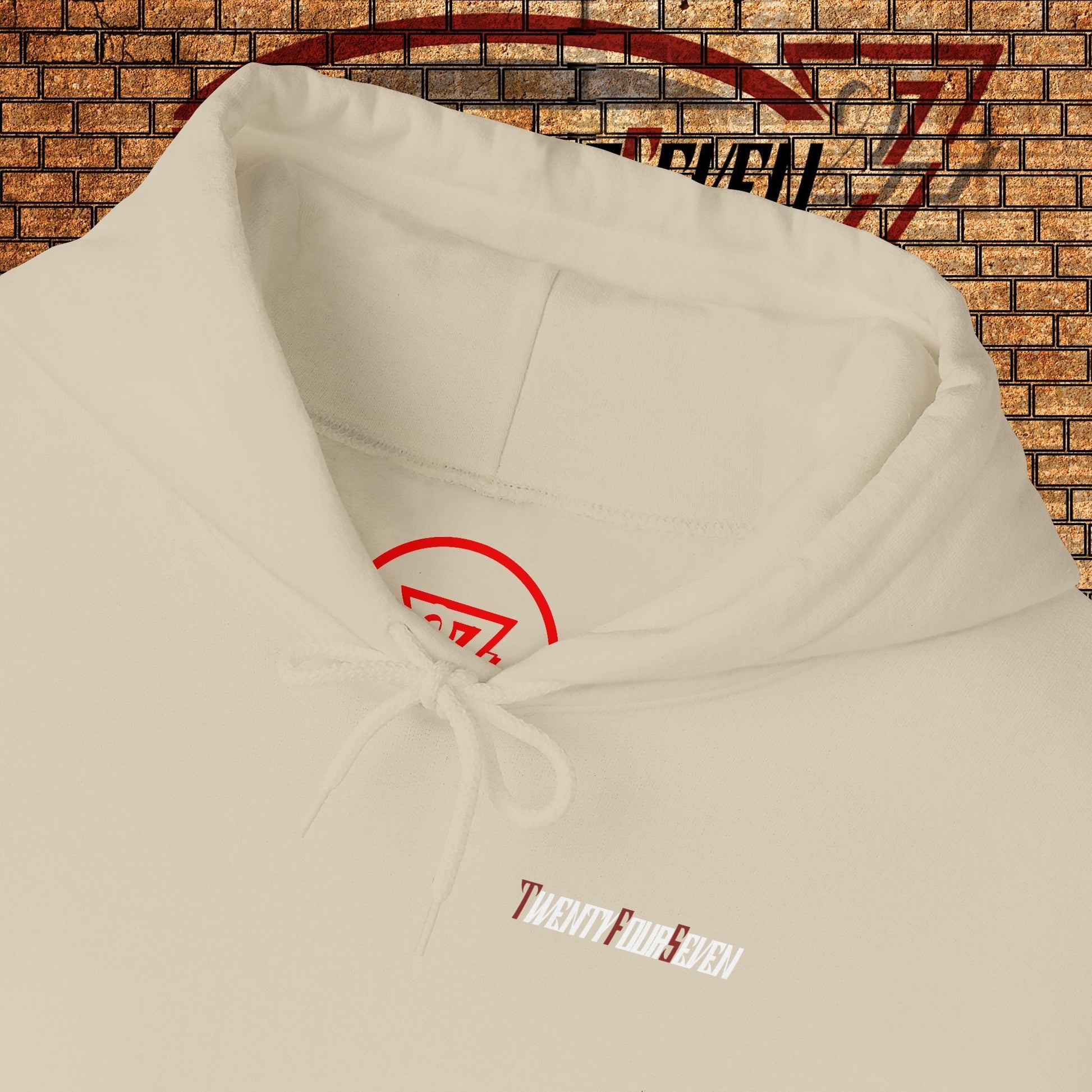 Close-up of unique printed hoodie with twentyfourseven logo and adjustable drawstring hood against brick wall background