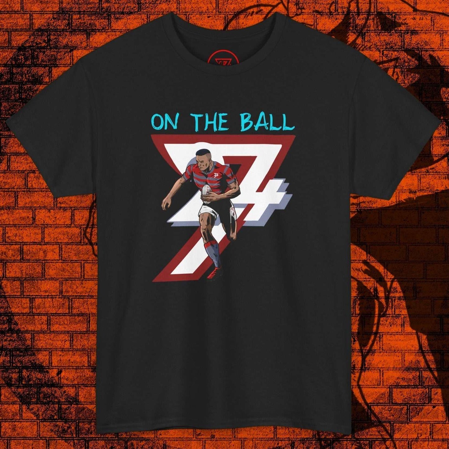 Comic-style rugby player running with ball graphic on black t-shirt with "On The Ball" text