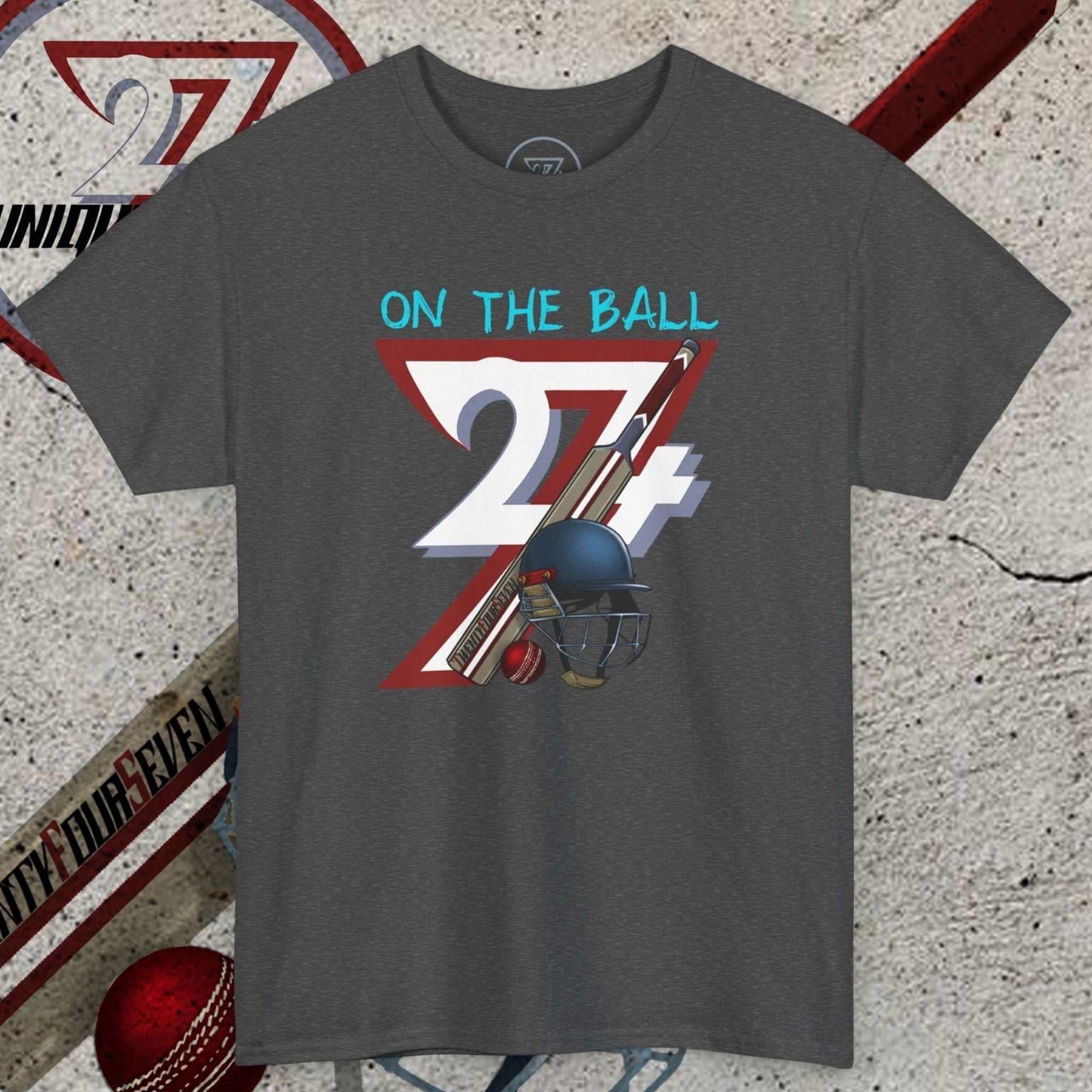 Dark gray cricket tee with hand-drawn vintage cricket bats, ball, and helmet illustration and "On The Ball 24/7" text design