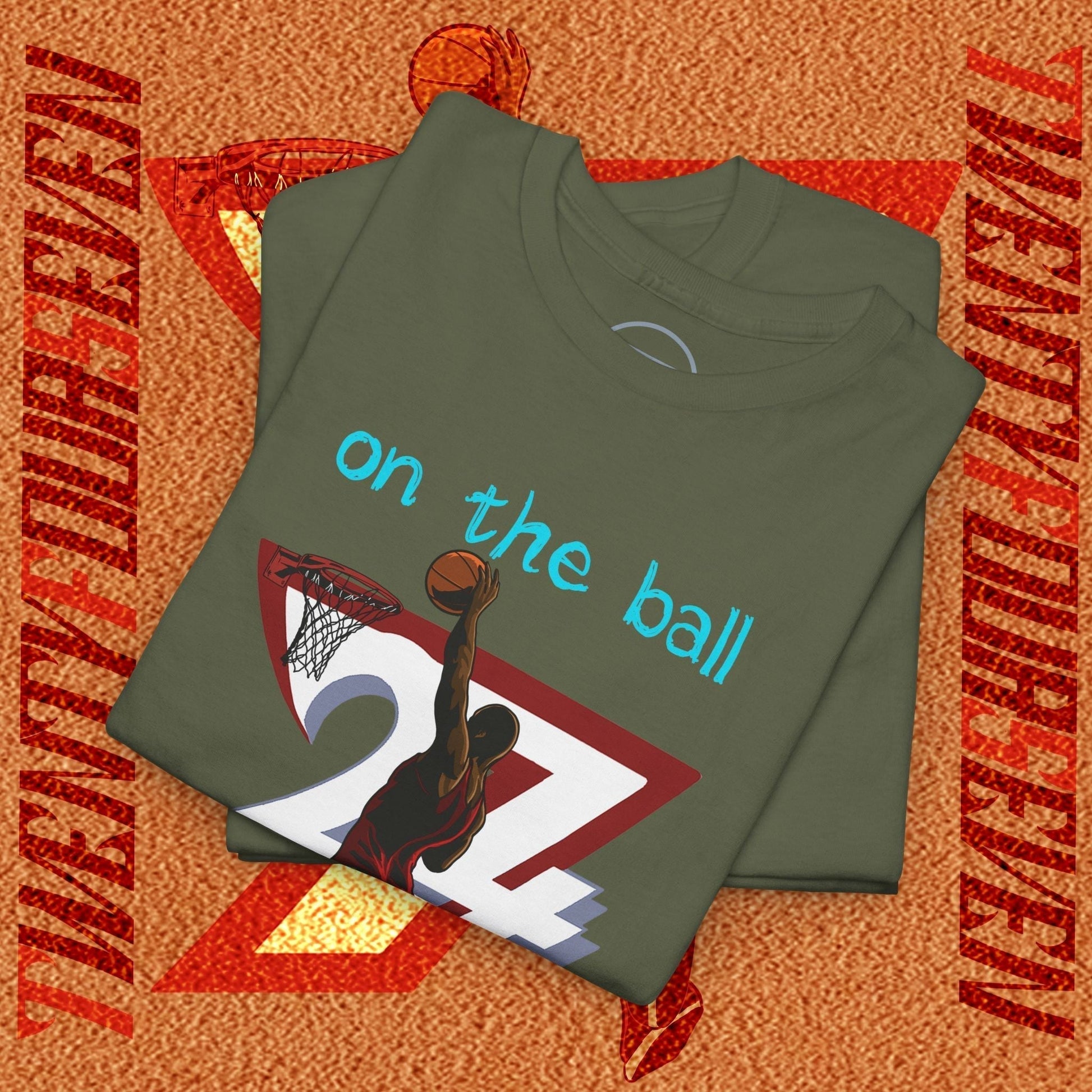 Folded 90s comic-style basketball tee with hand-drawn dunk graphic and "on the ball" text in blue on olive fabric