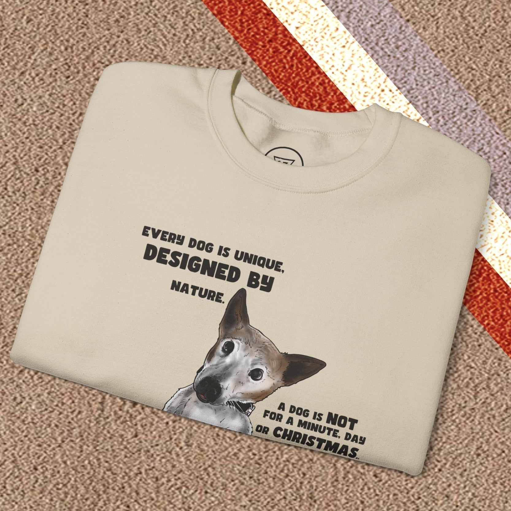 Folded beige dog lover sweatshirt with Jack Russel design and text on front, laid on patterned carpet