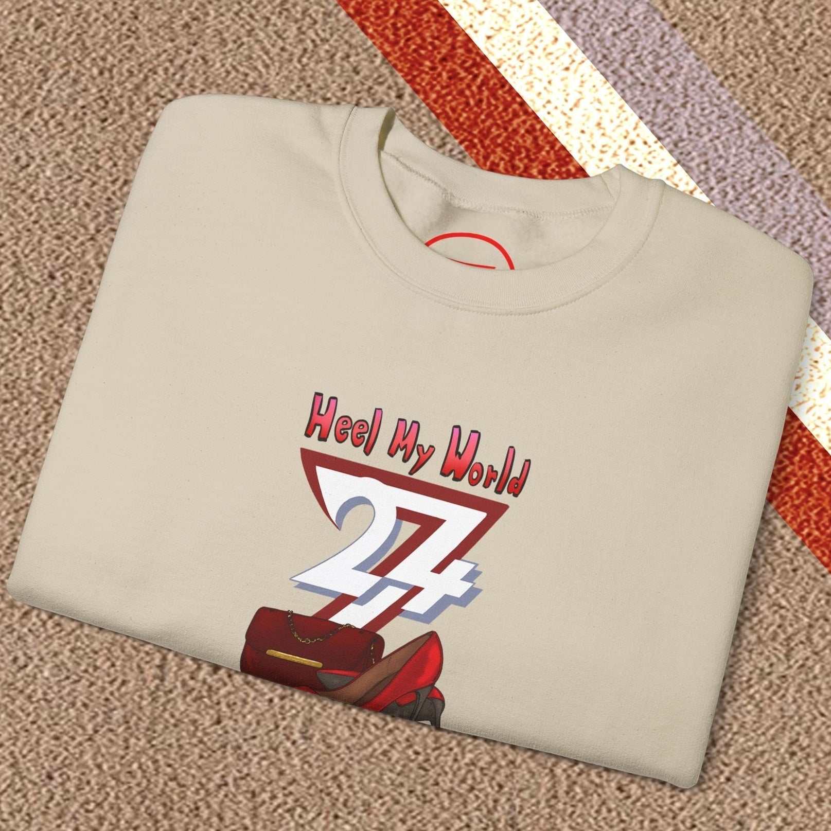 Folded beige graphic sweatshirt for women with colorful handbag and high-heel design and slogan Heel My World 27+ on the front