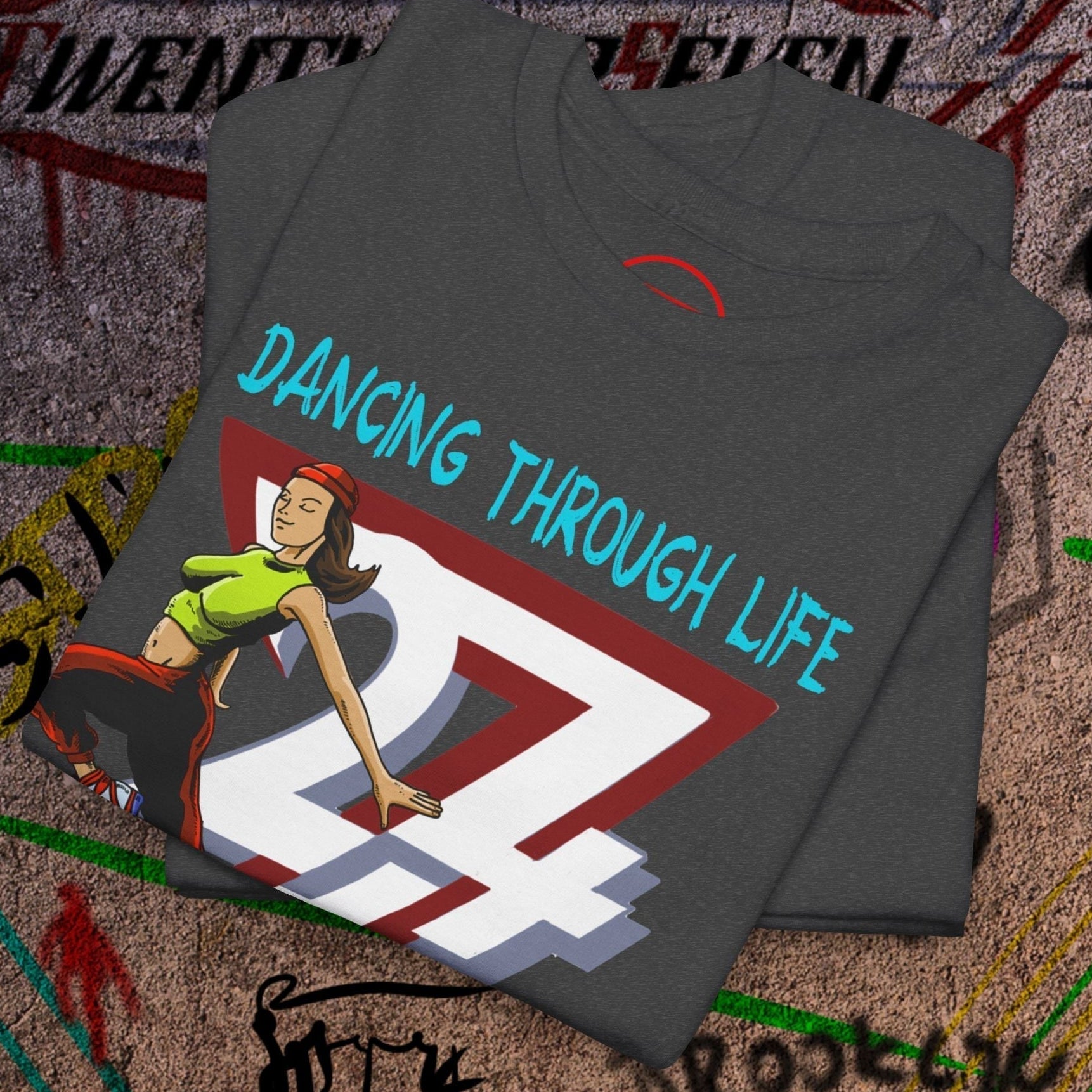 Folded black Dancing Girl Tee with hand-drawn female dancer and "Dancing Through Life" text on street art background