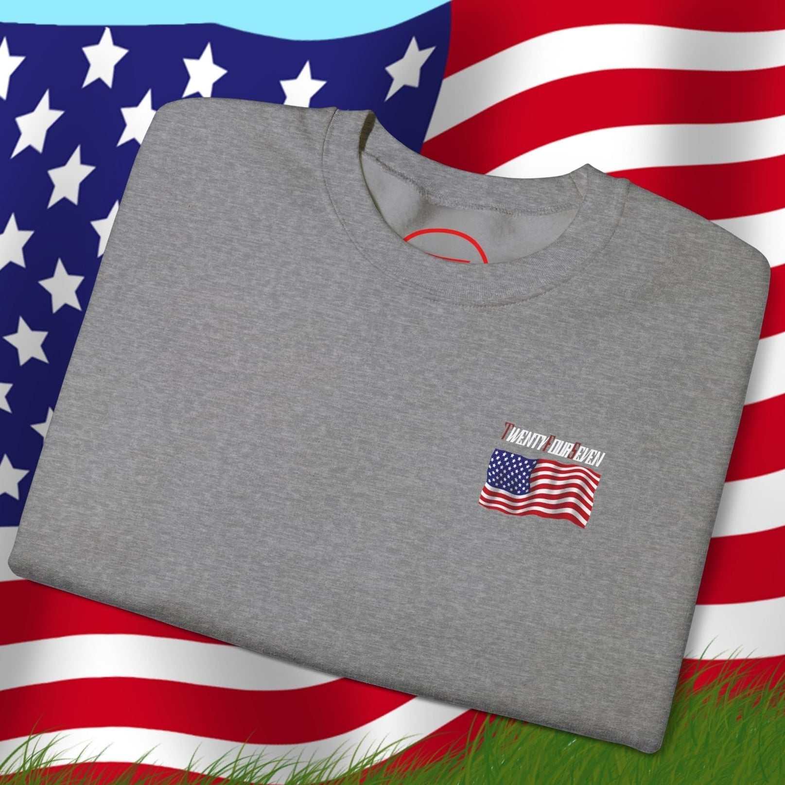 Folded gray US Flag Sweatshirt with small American flag design on front, displayed over a large waving US flag background