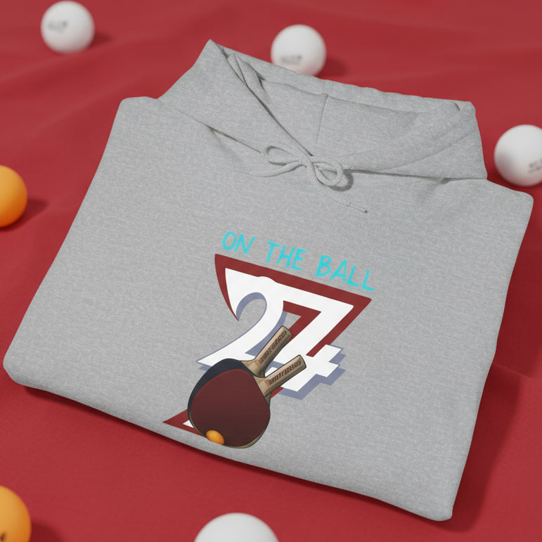 Folded gray ping pong hoodie with hand-drawn paddles and ball design and "On The Ball" text