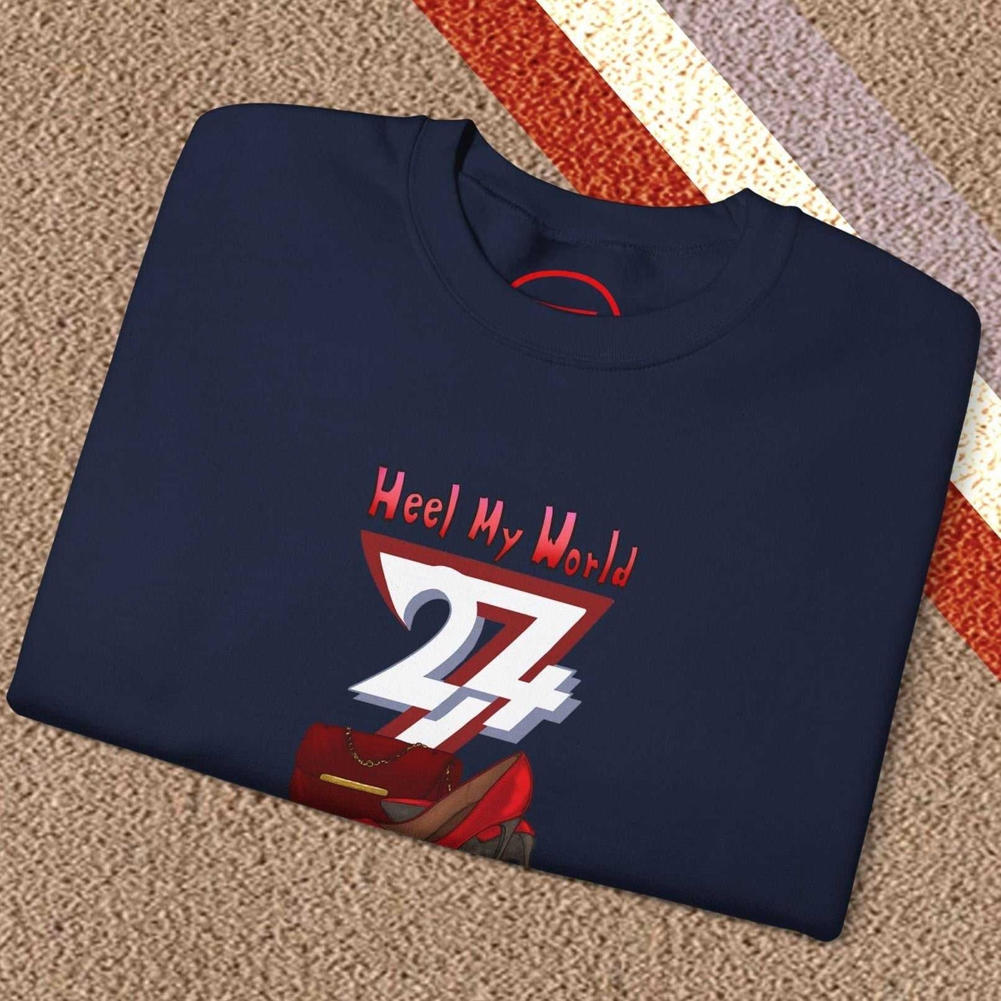 Folded navy graphic sweatshirt for women with red handbag and high-heel illustration and "Heel My World" text design