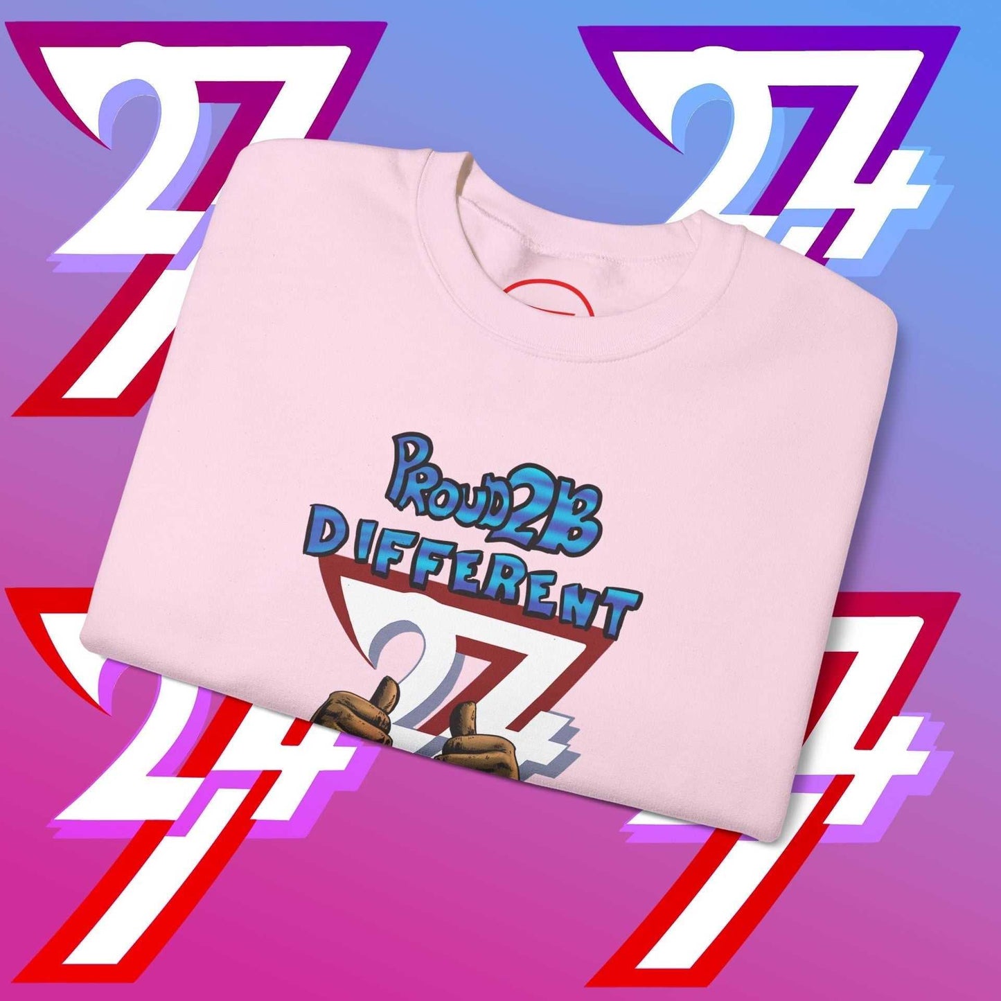 Folded pink artistic sweatshirt with "proud 2 b different" slogan and hand-drawn graphic on colorful background