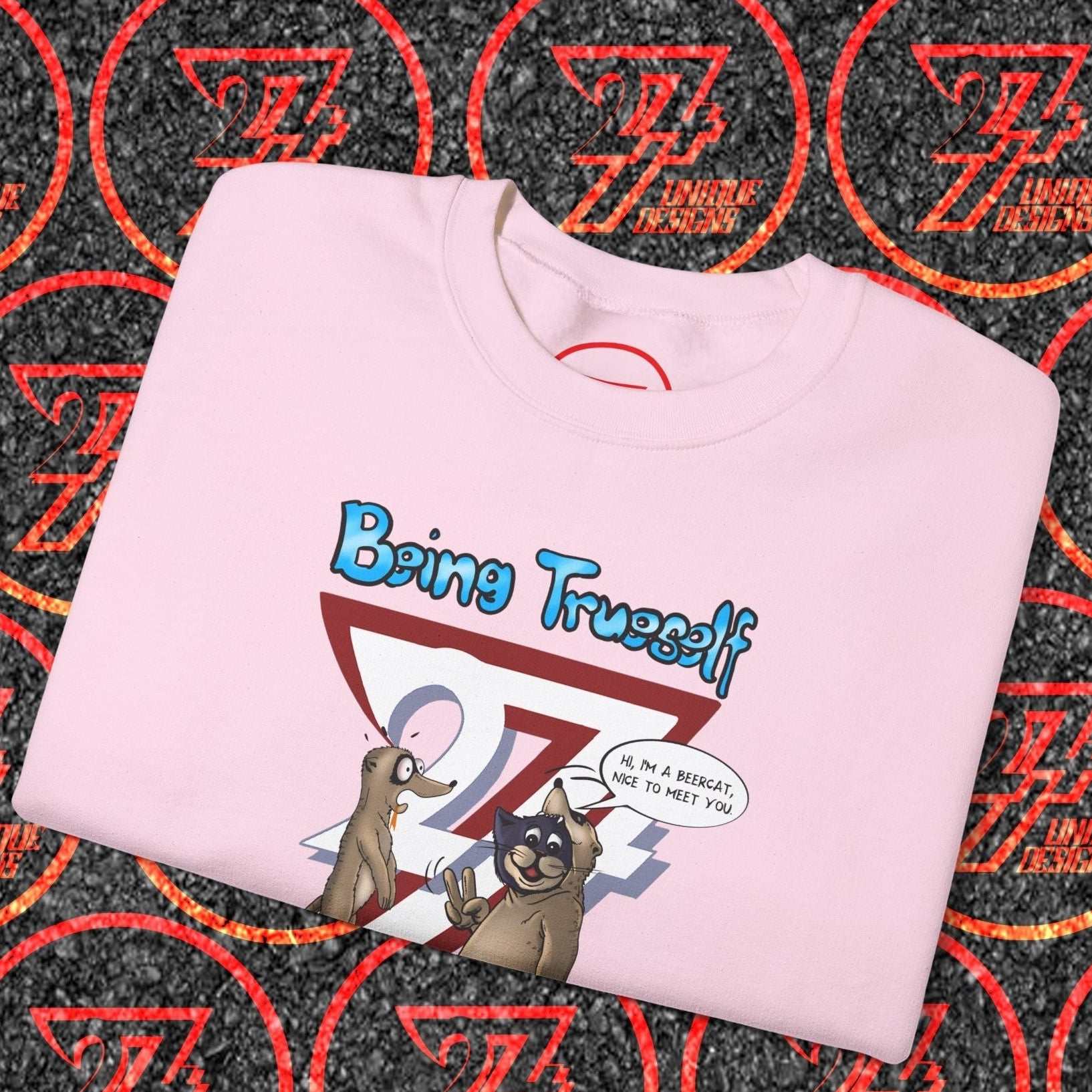 Folded pink sweatshirt with cartoon cat and meerkat design and "Being True Self" slogan