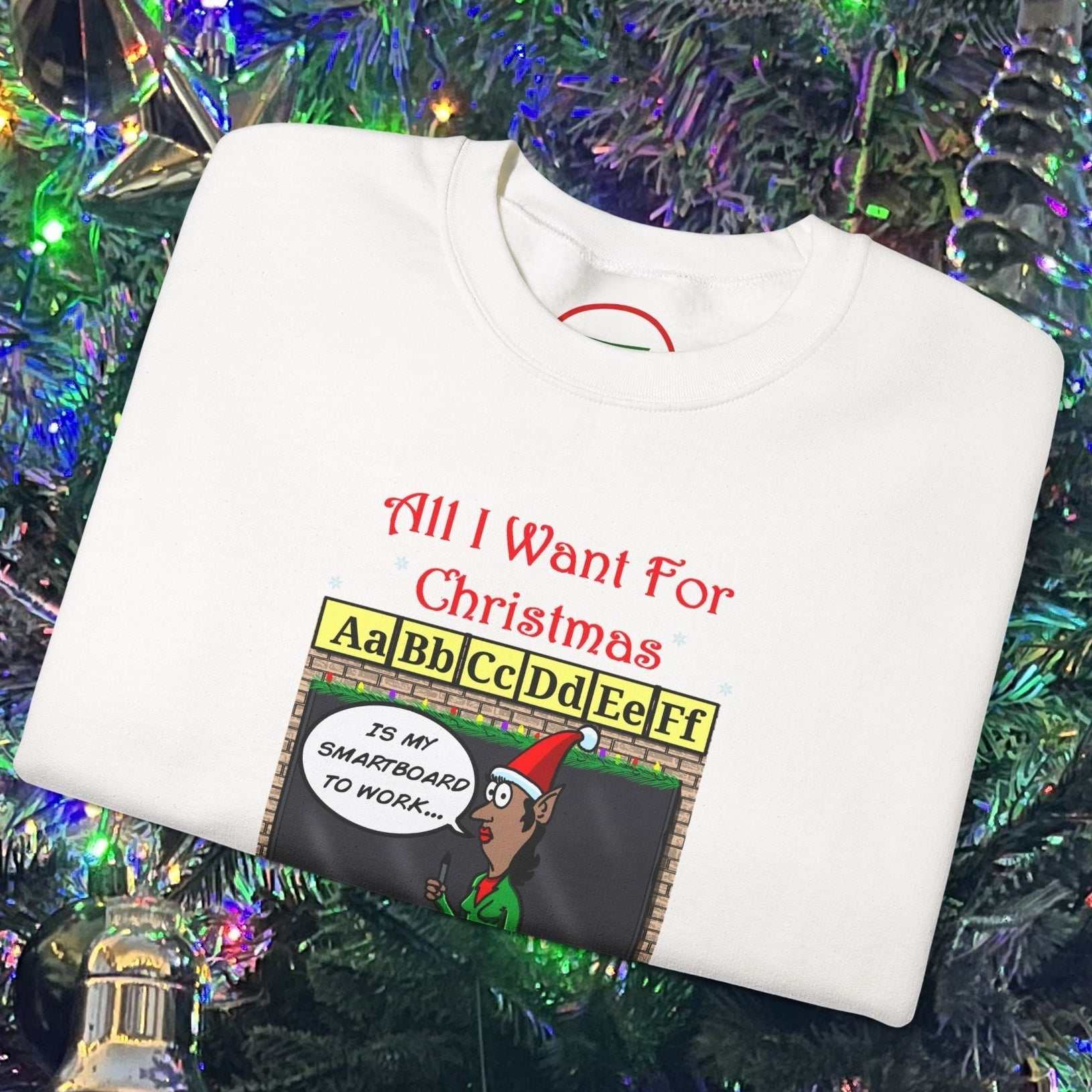 Folded white Christmas teacher comic sweatshirt with funny cartoon design on Christmas tree background