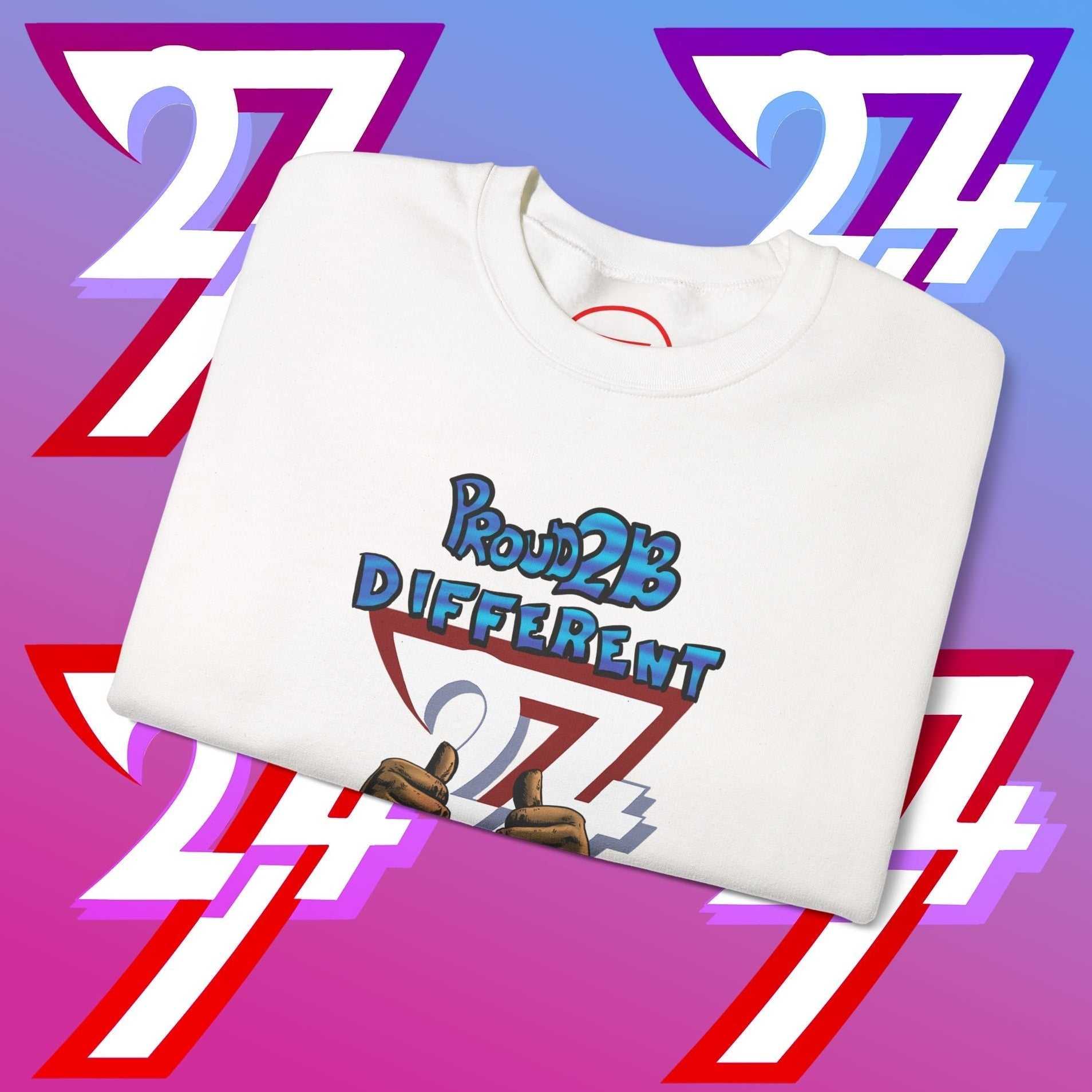 Folded white artistic sweatshirt with "Proud 2 B Different" slogan and hand-drawn graphic on purple and pink gradient background