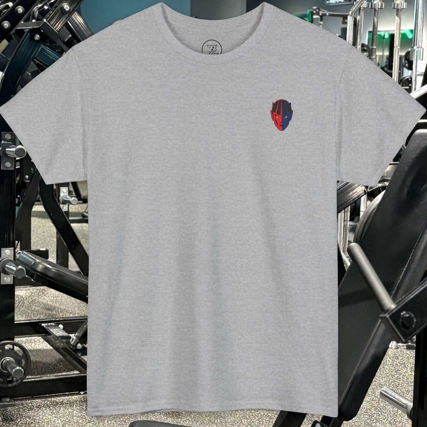 Grey bodybuilding tee with small comic-style fitness character graphic in gym setting