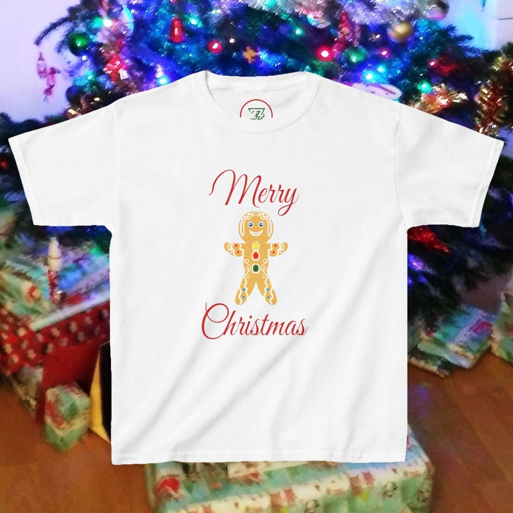 Kids white Gingerbread Man T-shirt with Merry Christmas design in front of decorated Christmas tree and presents