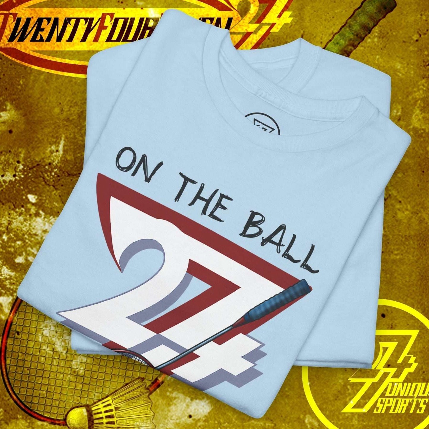 Light blue badminton tee with hand-drawn "On The Ball 24/7" design, soft cotton fabric, and classic fit.
