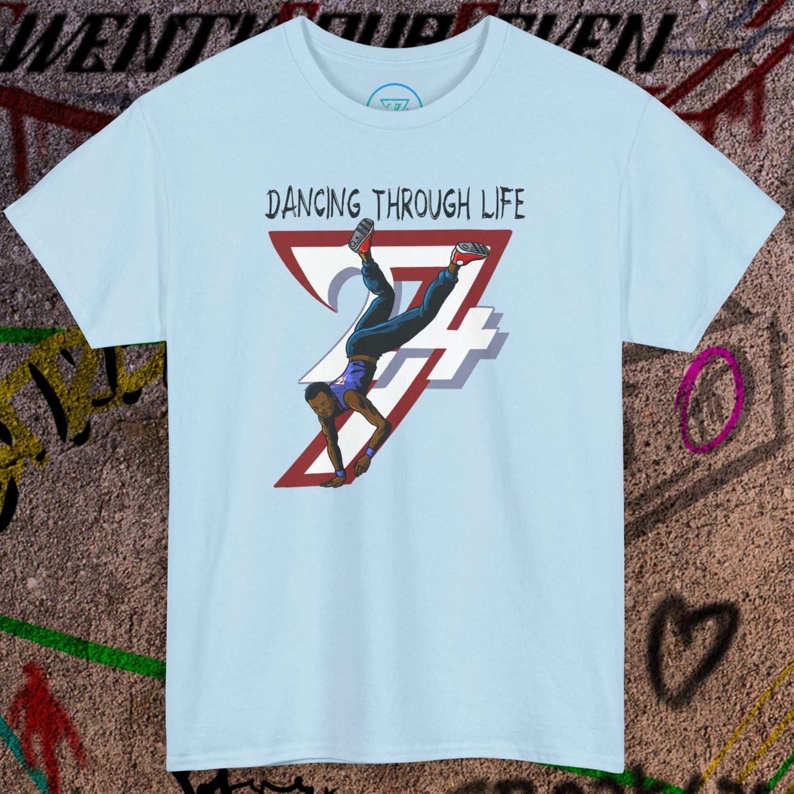 Light blue hip-hop dance tee with comic-style dancer graphic and "Dancing Through Life" text