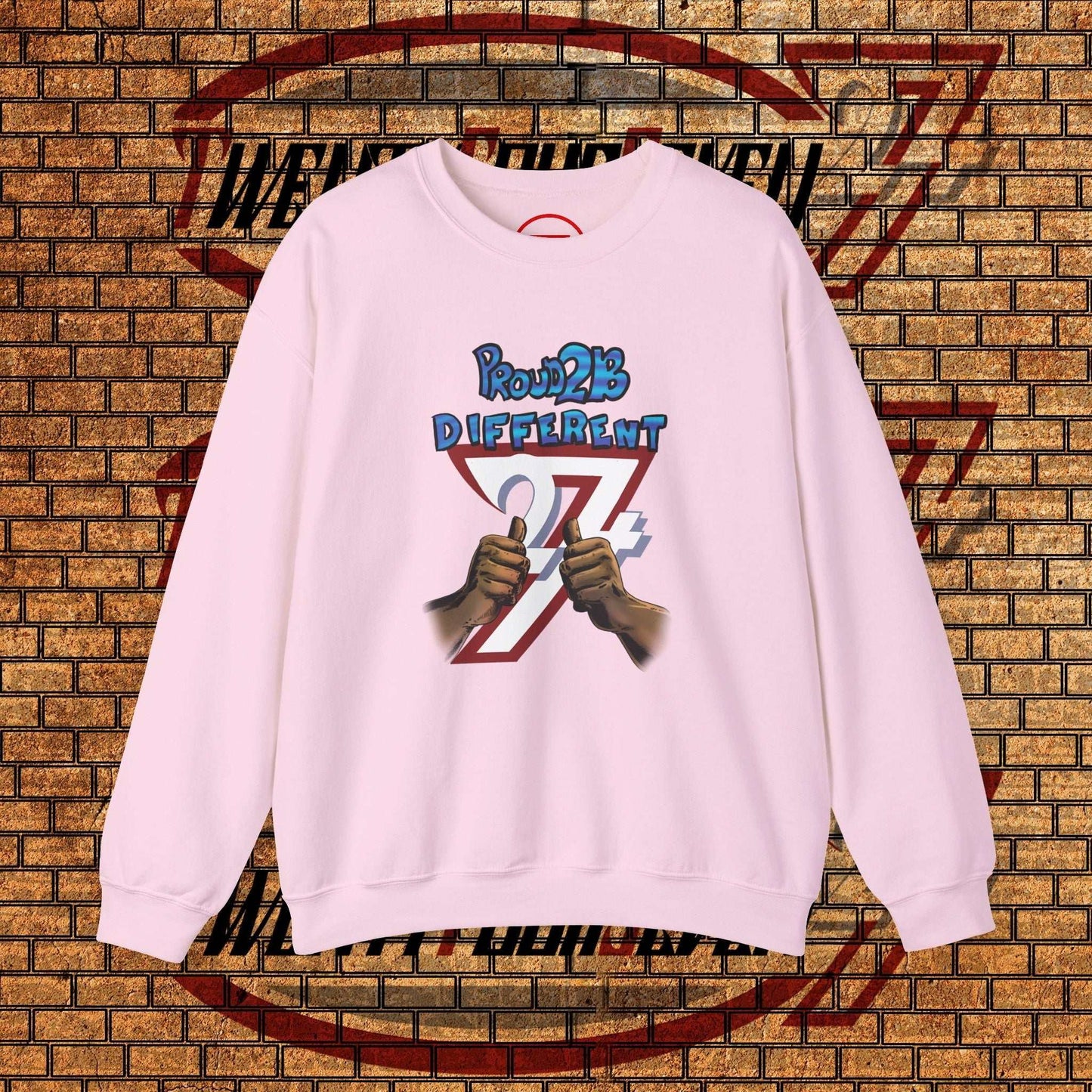 Light pink artistic sweatshirt with "Proud 2 B Different" slogan, hand-drawn graphic, and classic crewneck design.