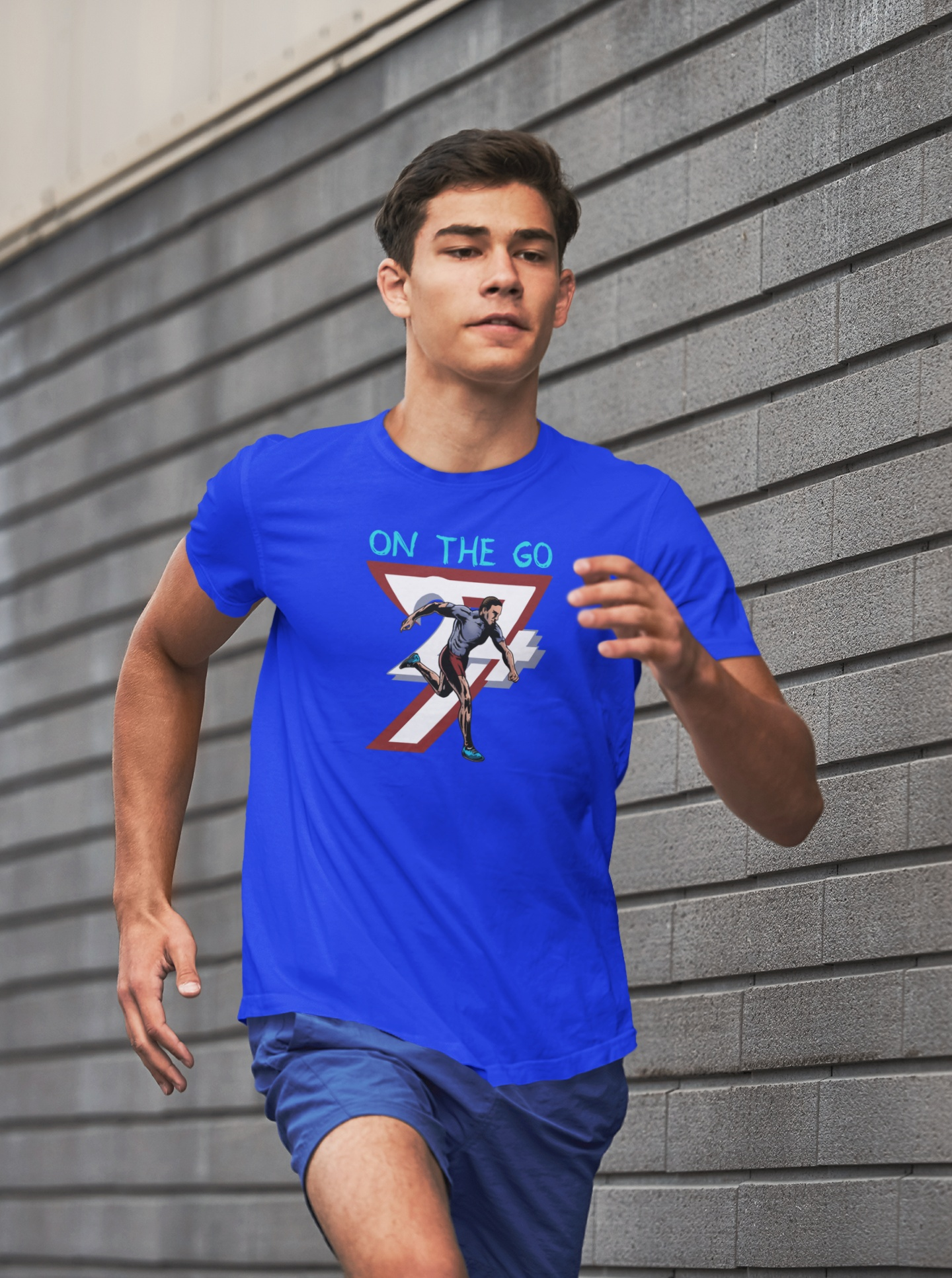 Male runner wearing a blue running T-shirt with a hand-drawn comic-style runner illustration and "ON THE GO" text, jogging outdoors.