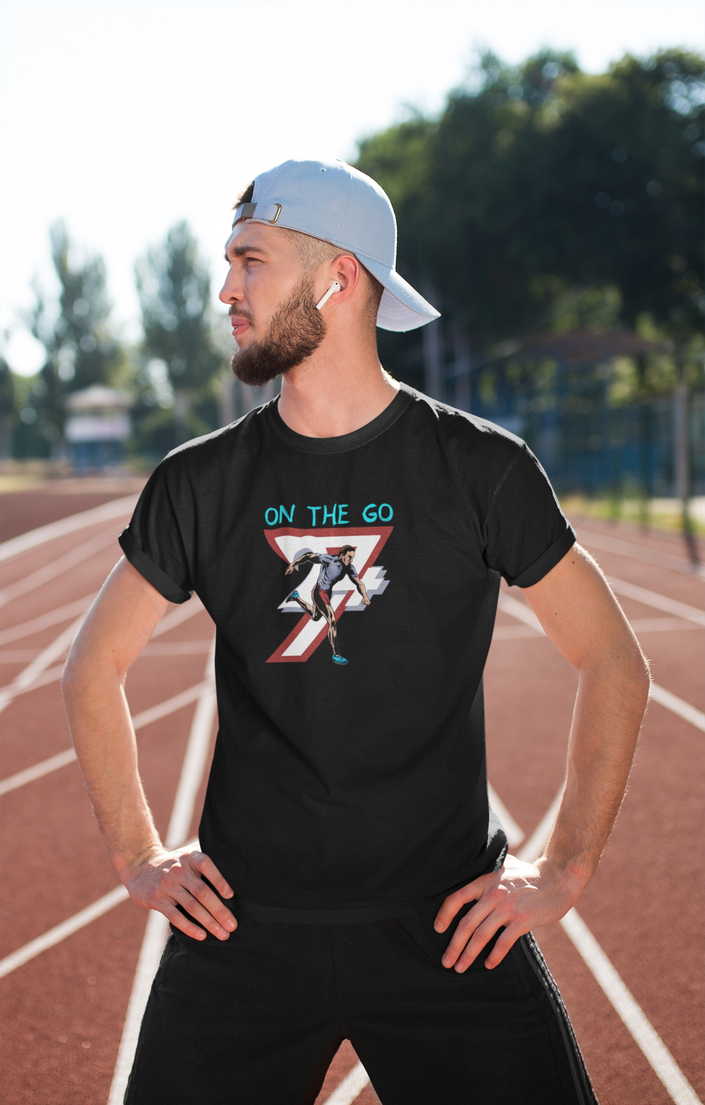 Man wearing black running T-shirt with hand-drawn comic-style runner illustration and "ON THE GO" text on outdoor track