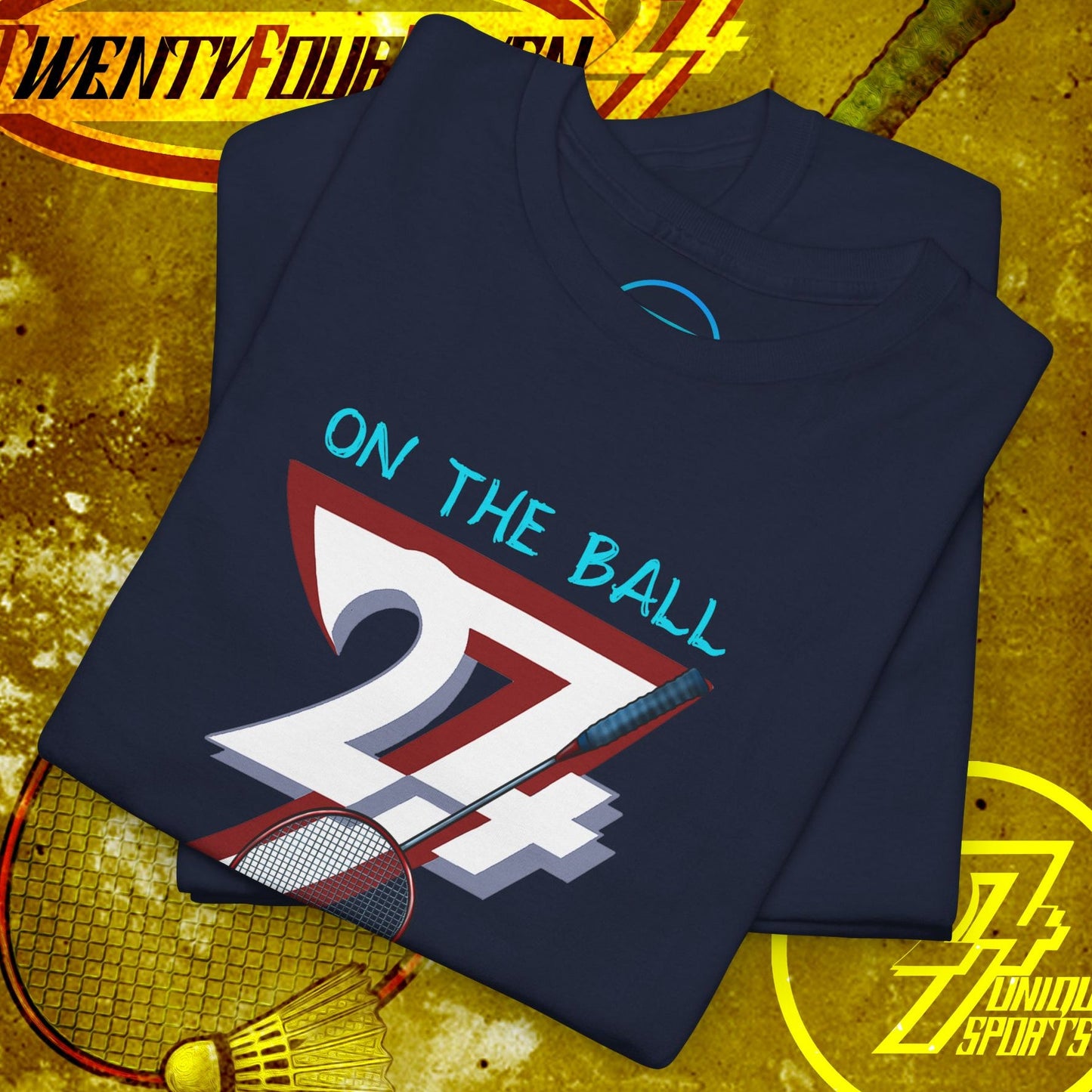 Navy badminton graphic tee with hand-drawn style "On the Ball 24/7" design, folded on textured sports background