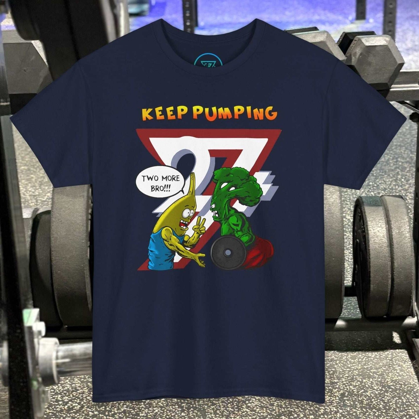 Navy broccoli gym tee with cartoon broccoli and banana characters lifting weights, "Keep Pumping" text, gym background