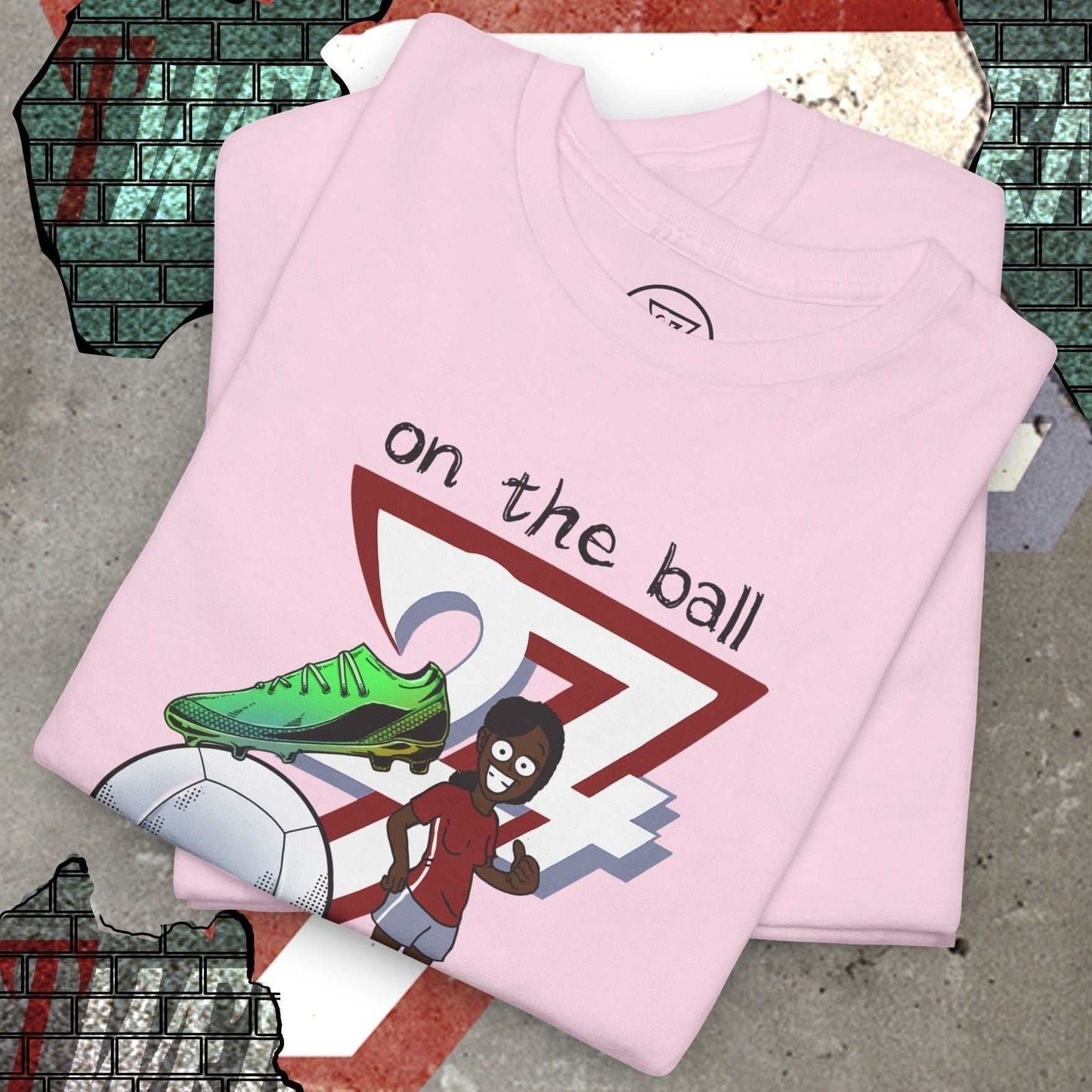 Pink women's football boot tee with hand-drawn soccer boot and cartoon player graphic, soft cotton, casual fit