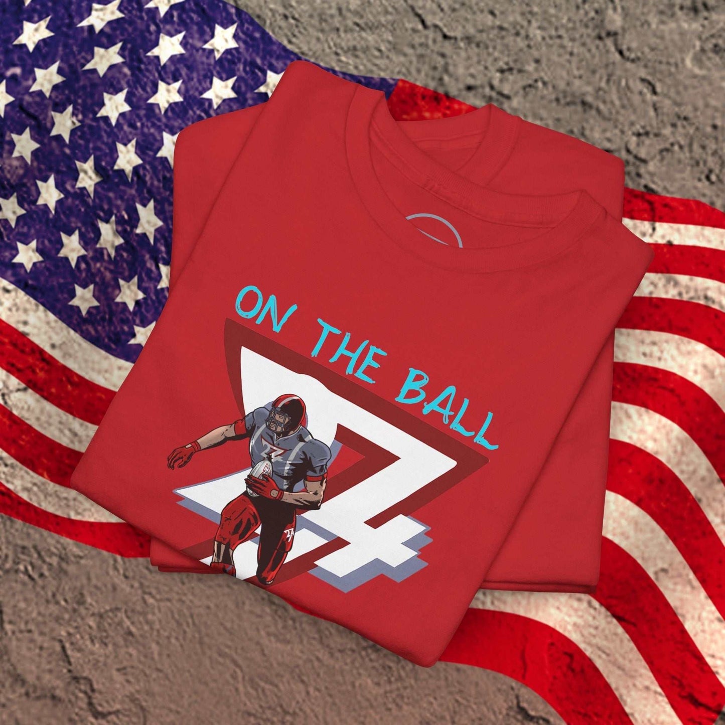 Red American football tee with hand-drawn comic-style graphic of a player and text "ON THE BALL" placed on an American flag background