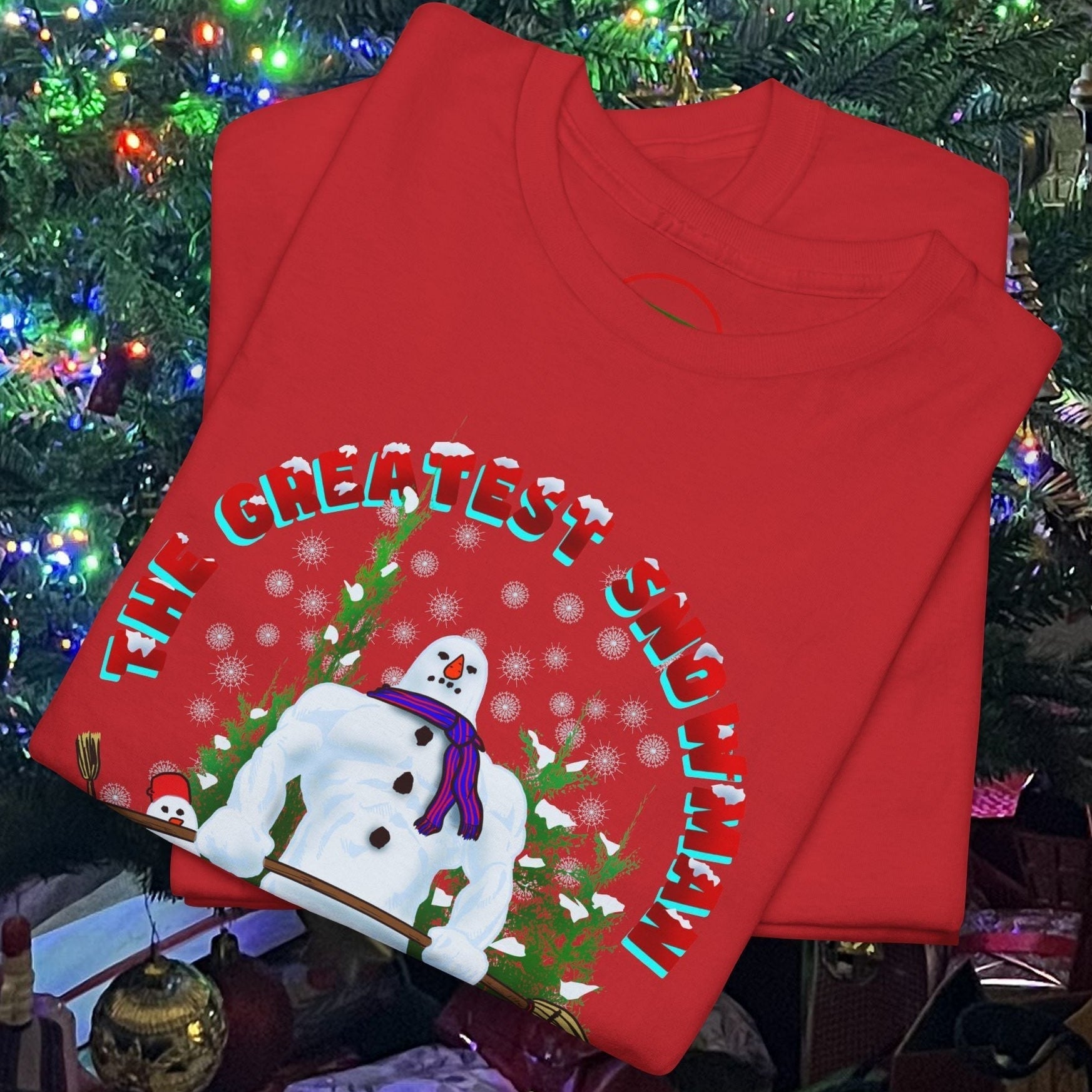 Red Greatest Snowman Gym T-Shirt with a cartoon snowman lifting dumbbells under a decorated Christmas tree background