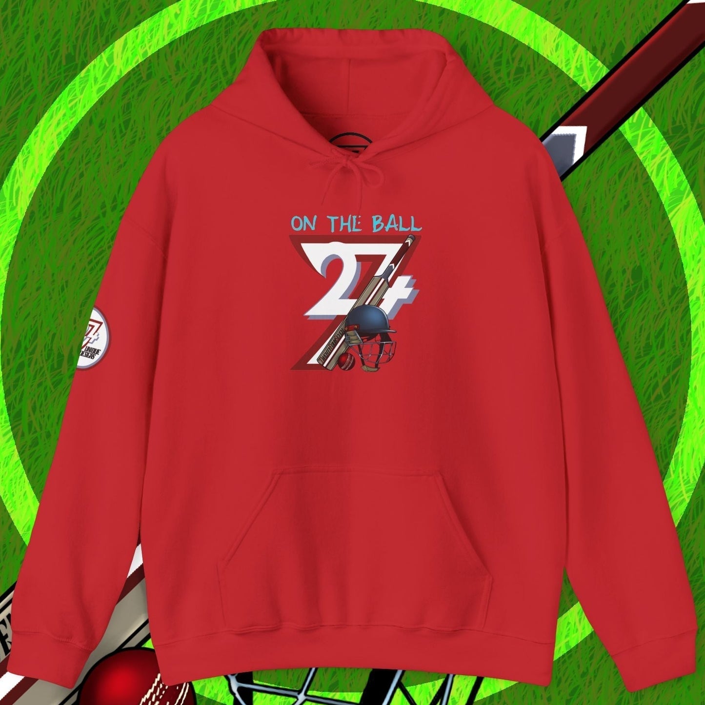 Red cricket hoodie sweatshirt with unique cricket-themed illustration and kangaroo pocket on green grass background with cricket bat, ball, and helmet