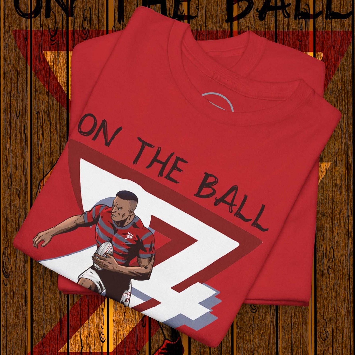 Red rugby sports tee with hand-drawn player illustration and "On The Ball" text on wooden background